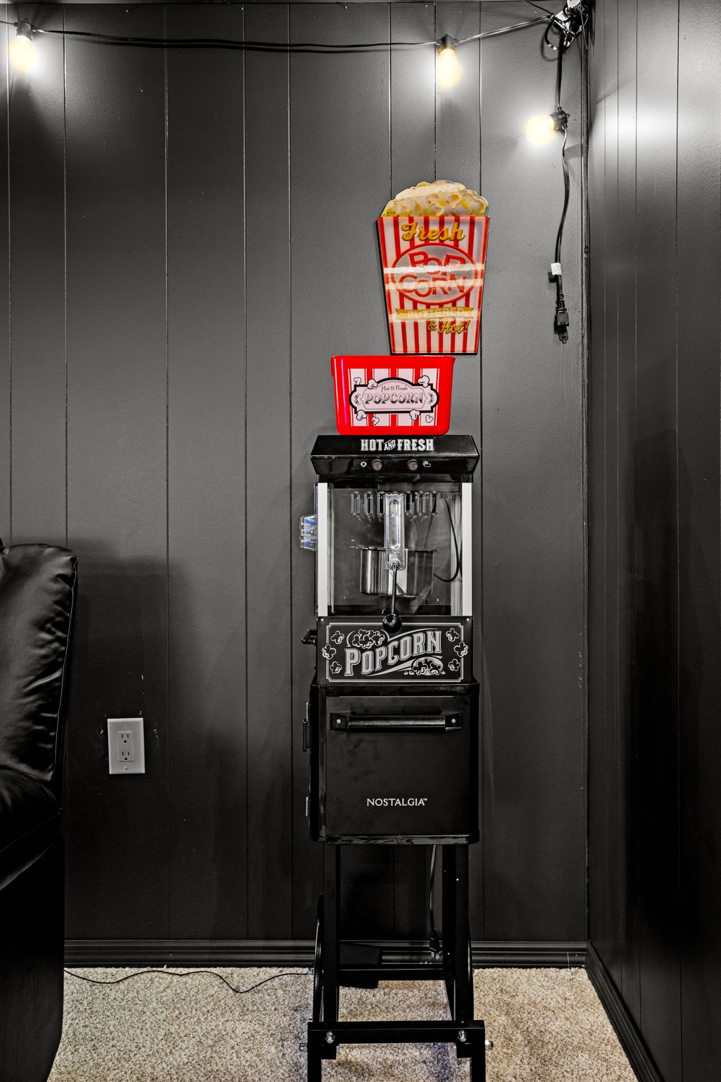 No movie night is complete without snacks! A retro-style popcorn machine adds the perfect finishing touch to this theater setup.
