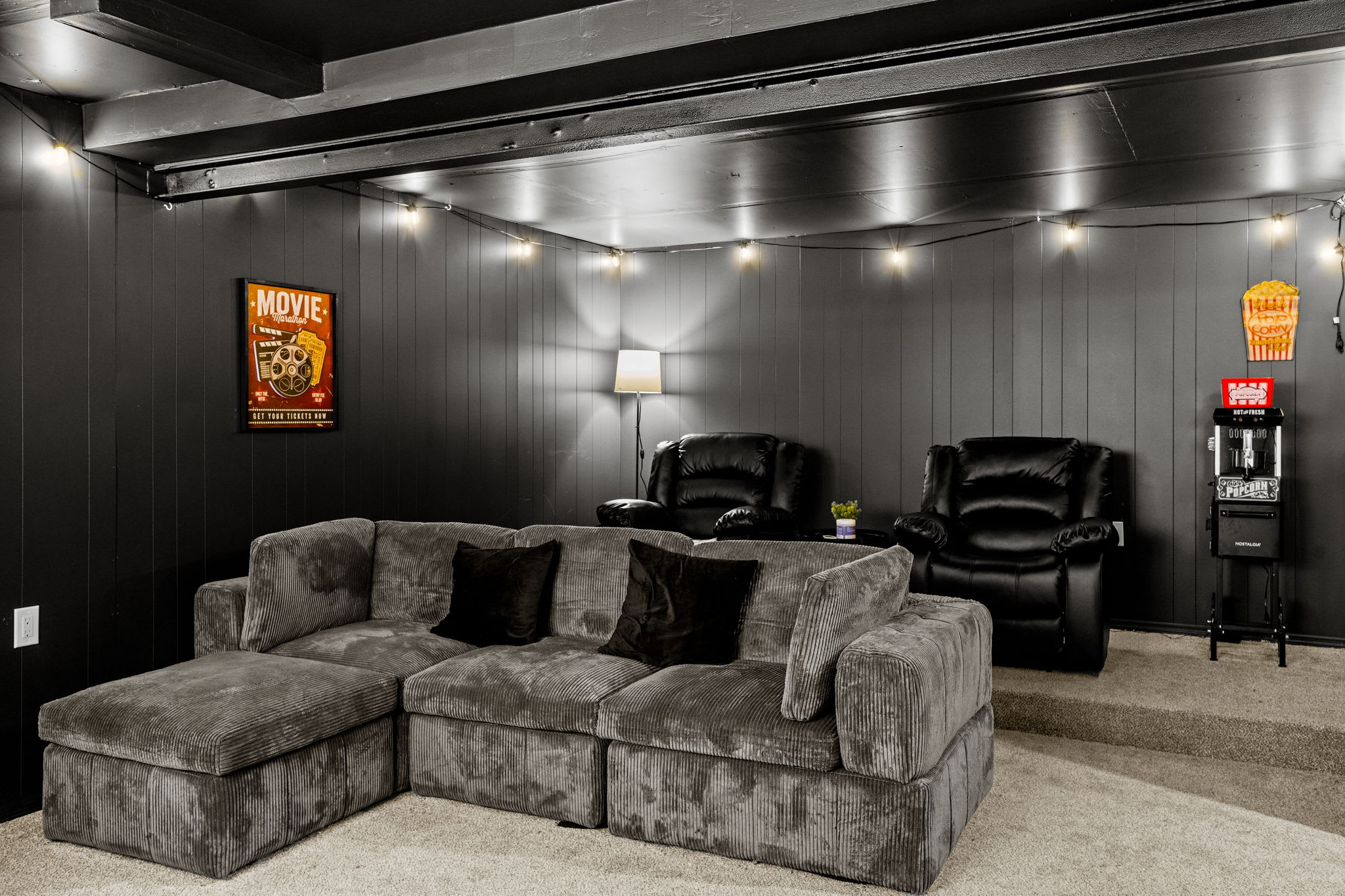 Black walls, warm lighting, and themed décor bring a nostalgic yet stylish ambiance to this entertainment space.