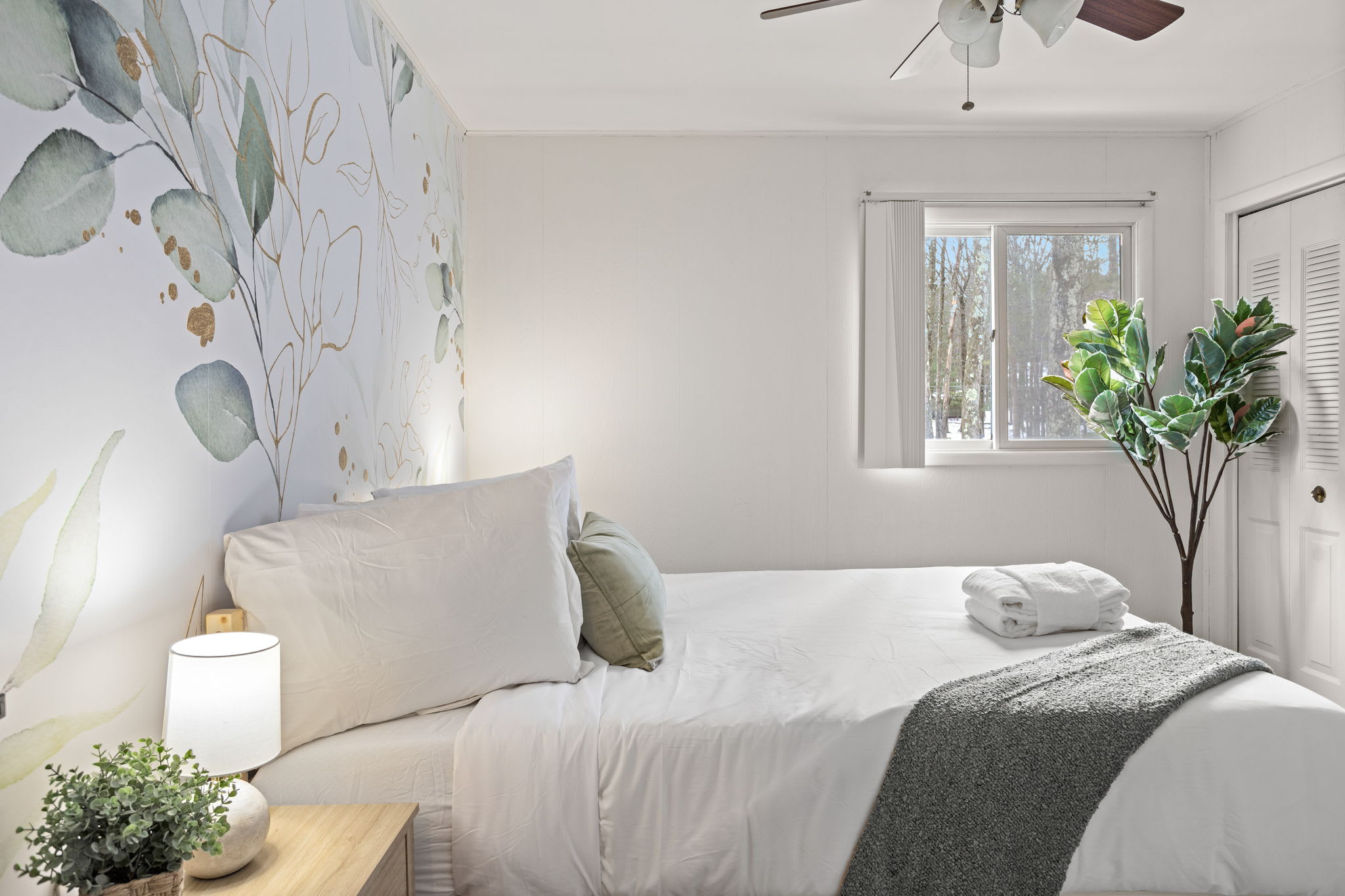 This well-lit bedroom offers cozy bedding, warm lighting, and an inviting ambiance. (1 Queen Size Bed)