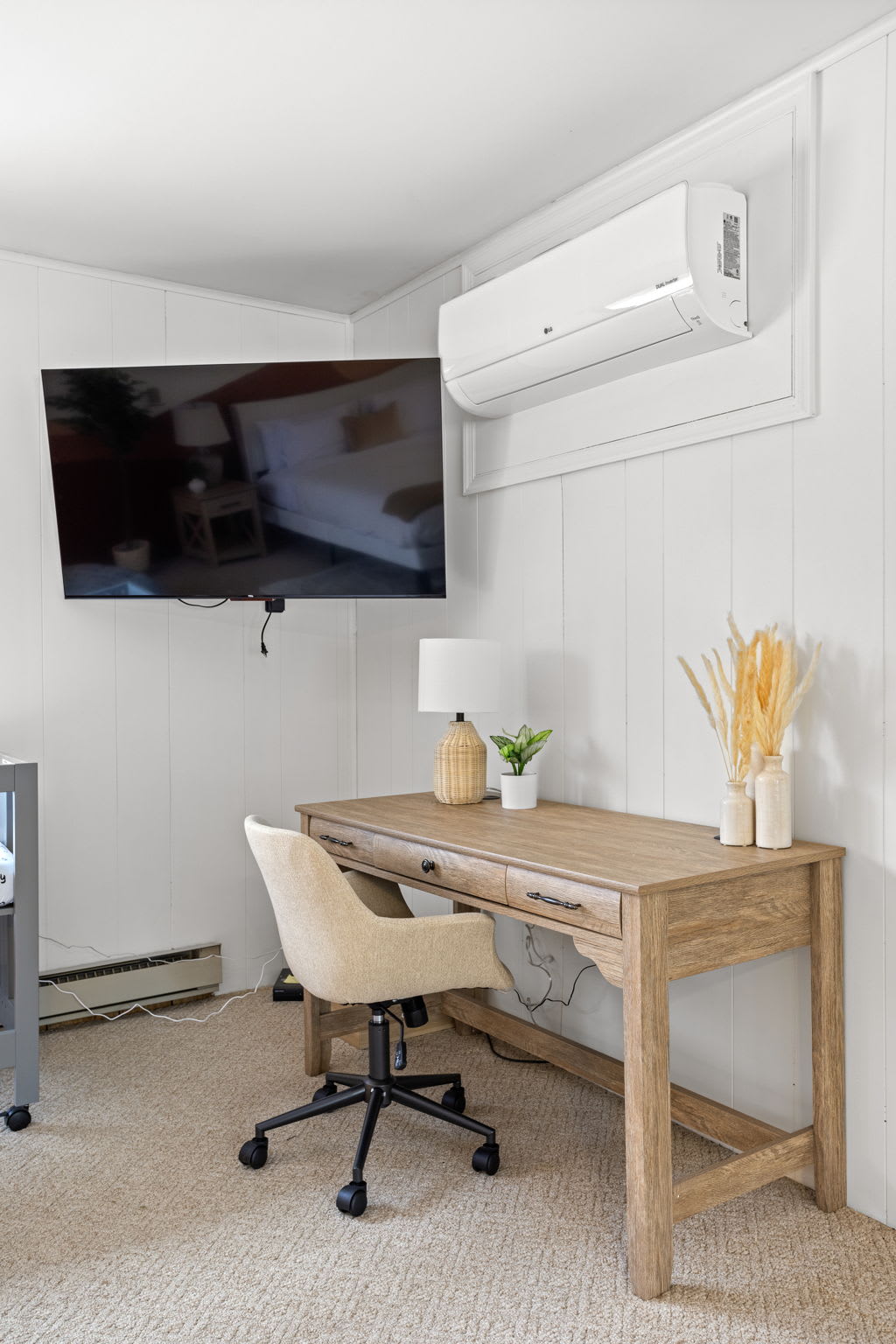 Whether you're working remotely or simply need a quiet space, this bedroom setup includes a sleek desk, comfortable chair, and a mounted TV for entertainment.