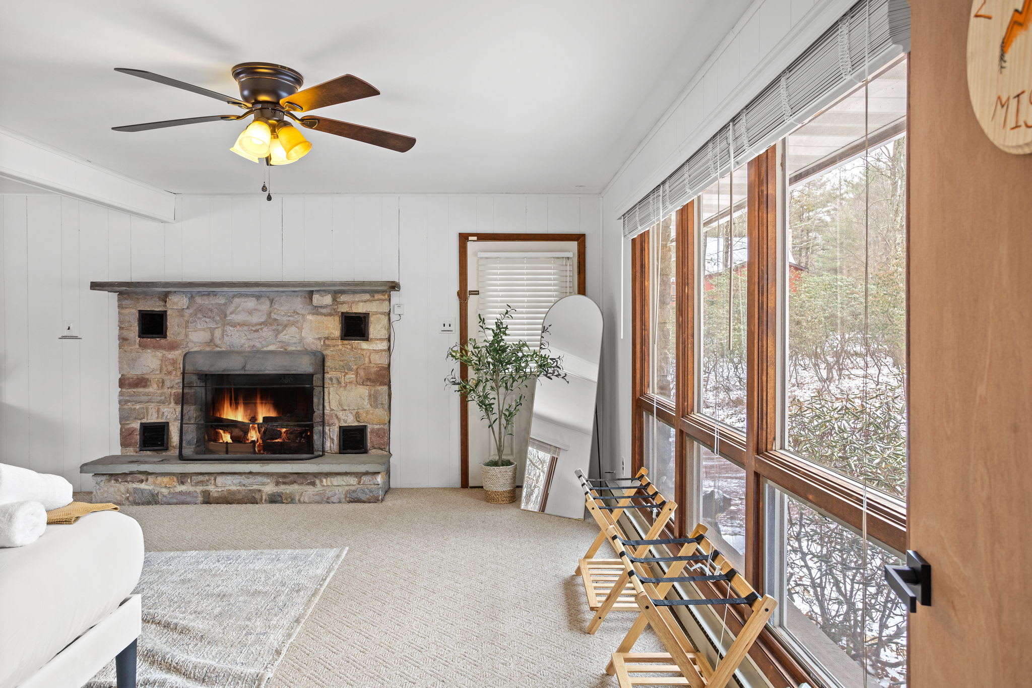 Enjoy a roaring fire while taking in serene outdoor scenery through the expansive windows.