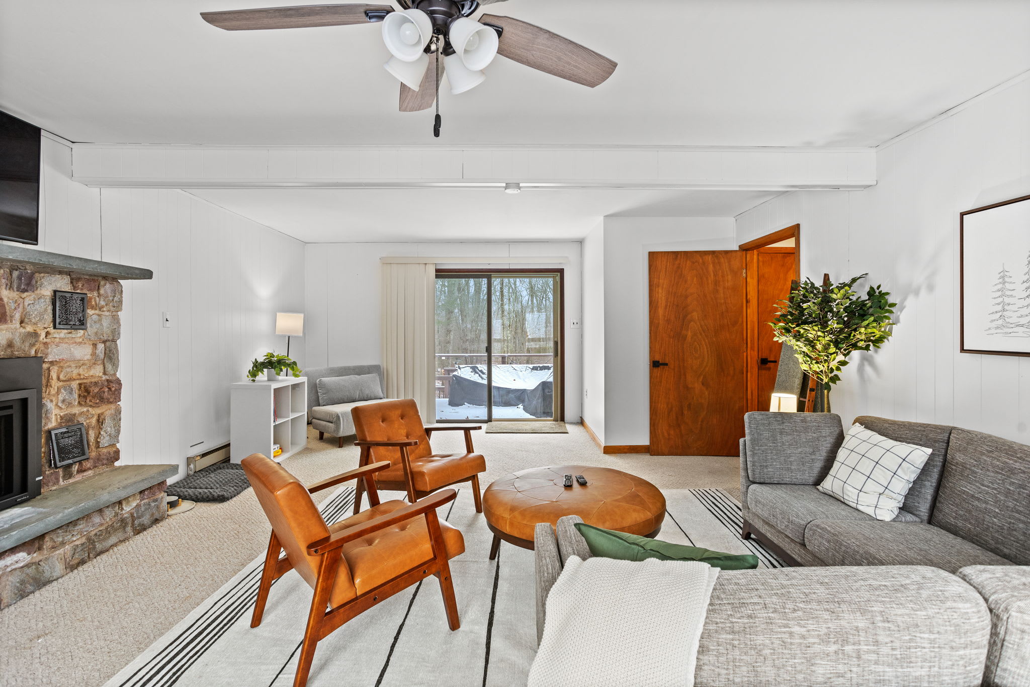 The rustic stone fireplace brings warmth and charm to this beautifully designed living area.