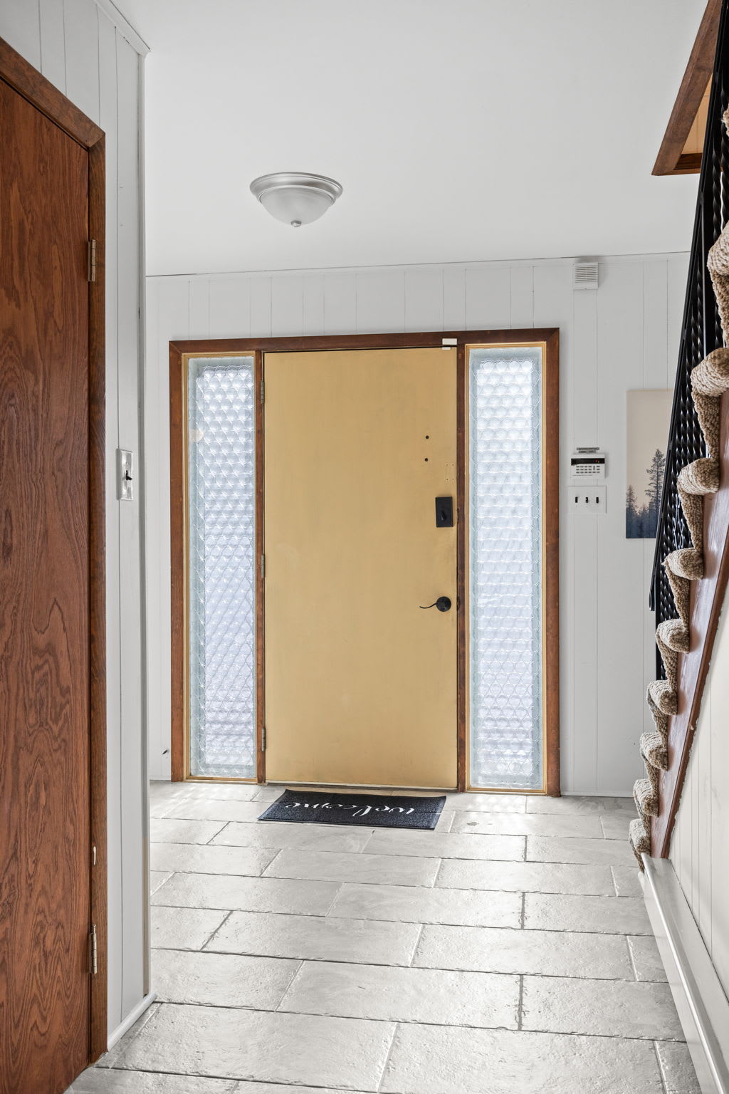 A bright and airy foyer with sleek tile flooring and warm wood accents, setting the tone for a comfortable and inviting stay.
