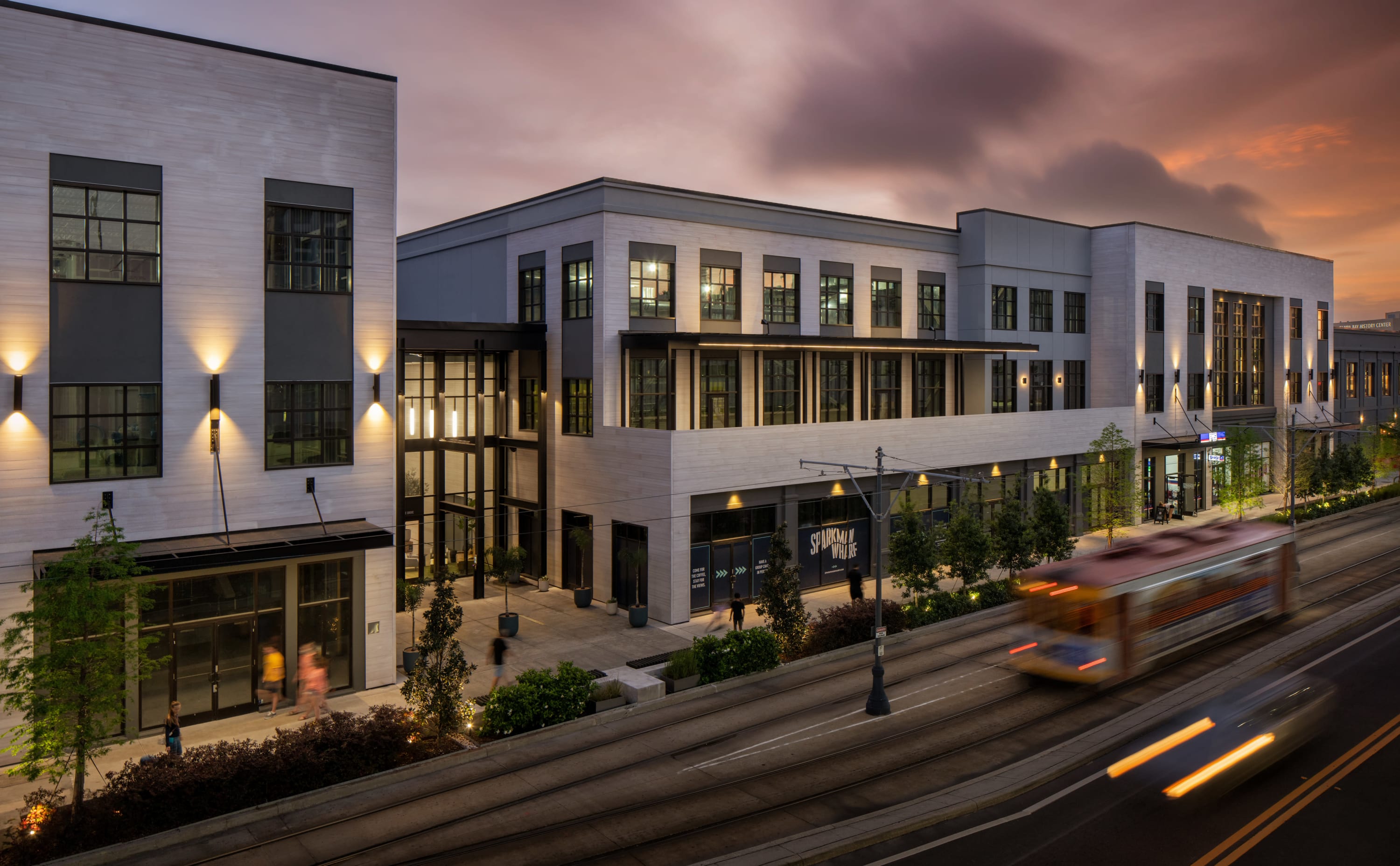 Modern building exterior glowing at dusk with clean architectural lines.
