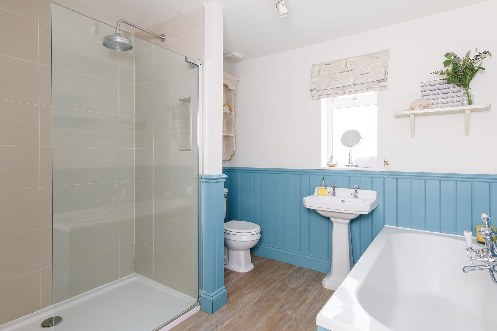 The bathroom is spacious with a large separate shower and bath with shower head.