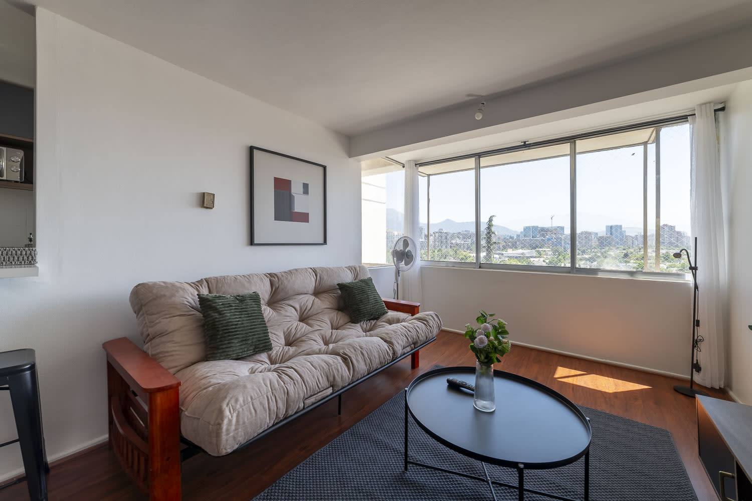 Relax in this bright living room with stunning city views, a comfy futon, and stylish decor—perfect for unwinding after a day of exploring.