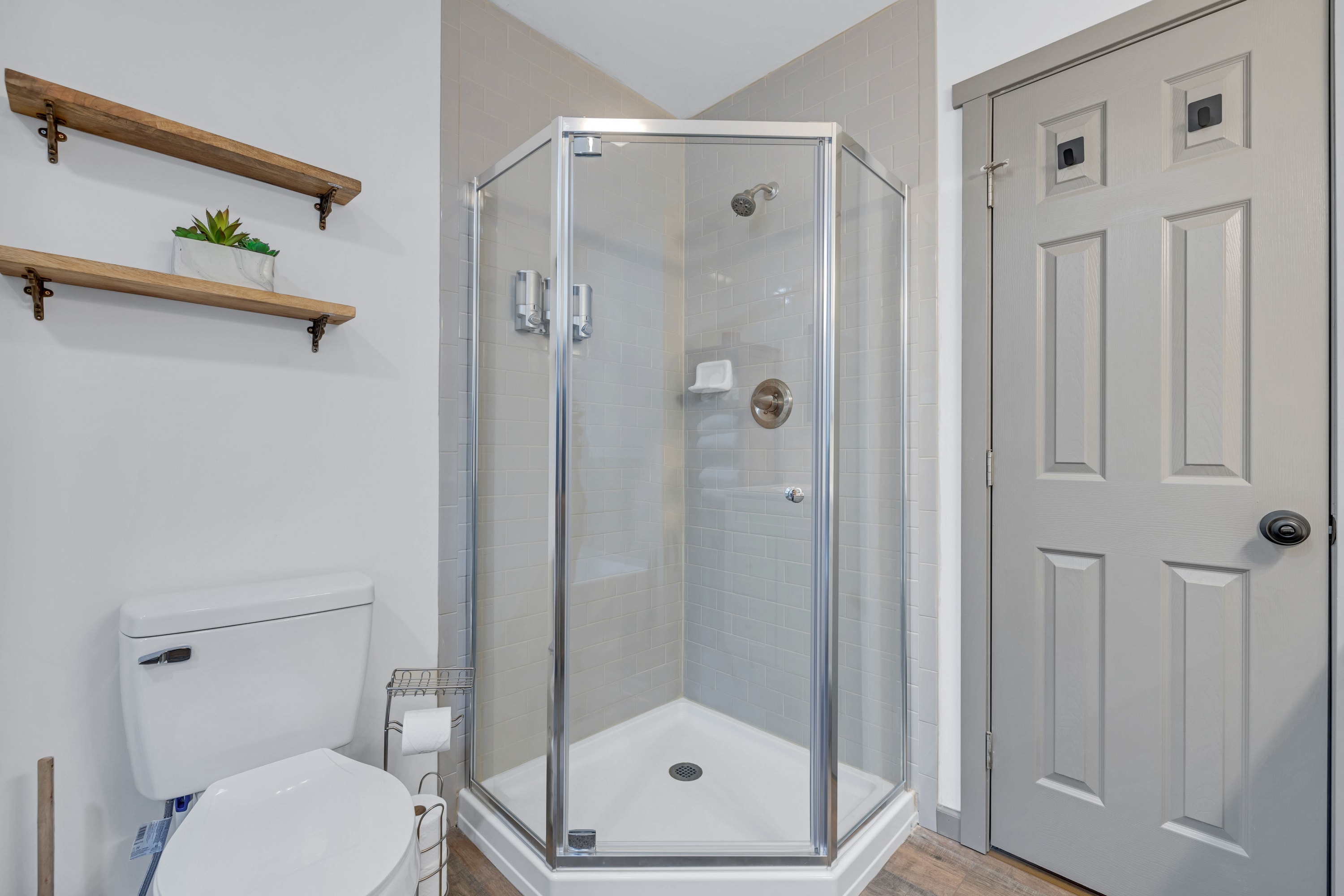 Master bathroom with a sleek corner stand-in shower with glass doors, providing a stylish and refreshing space to start your day.