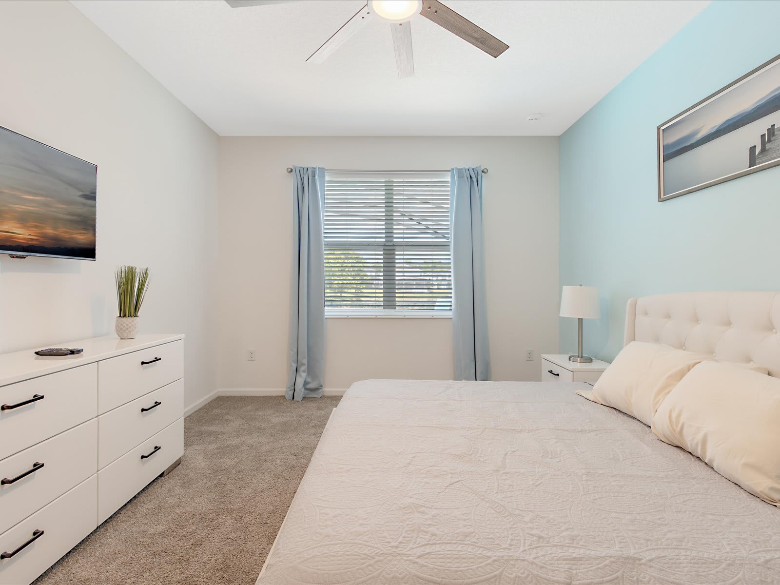 Calm bedroom w/ soft tones, cozy bed, & natural light.