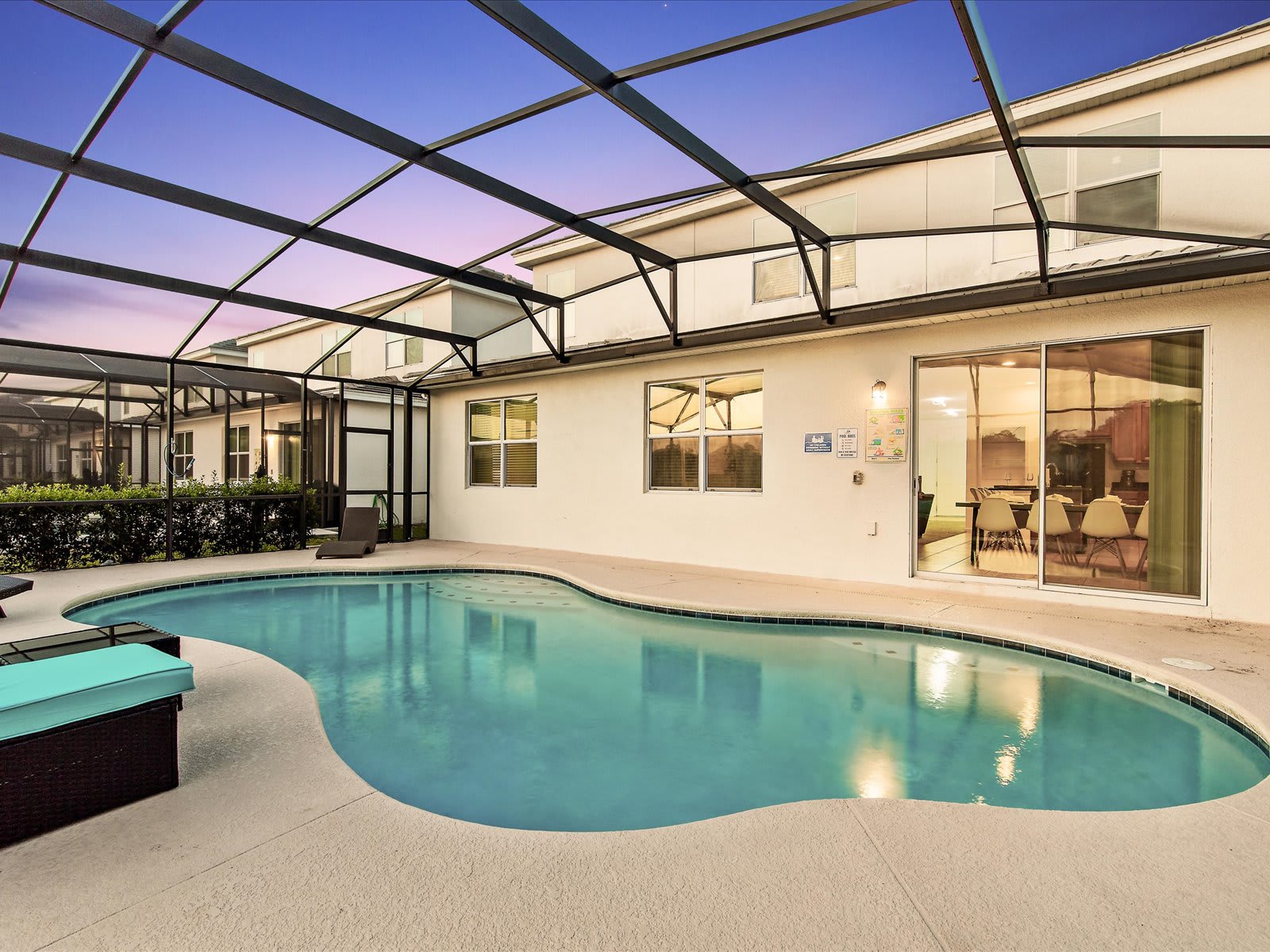 Screened-in pool glowing at dusk, perfect for a peaceful evening swim.