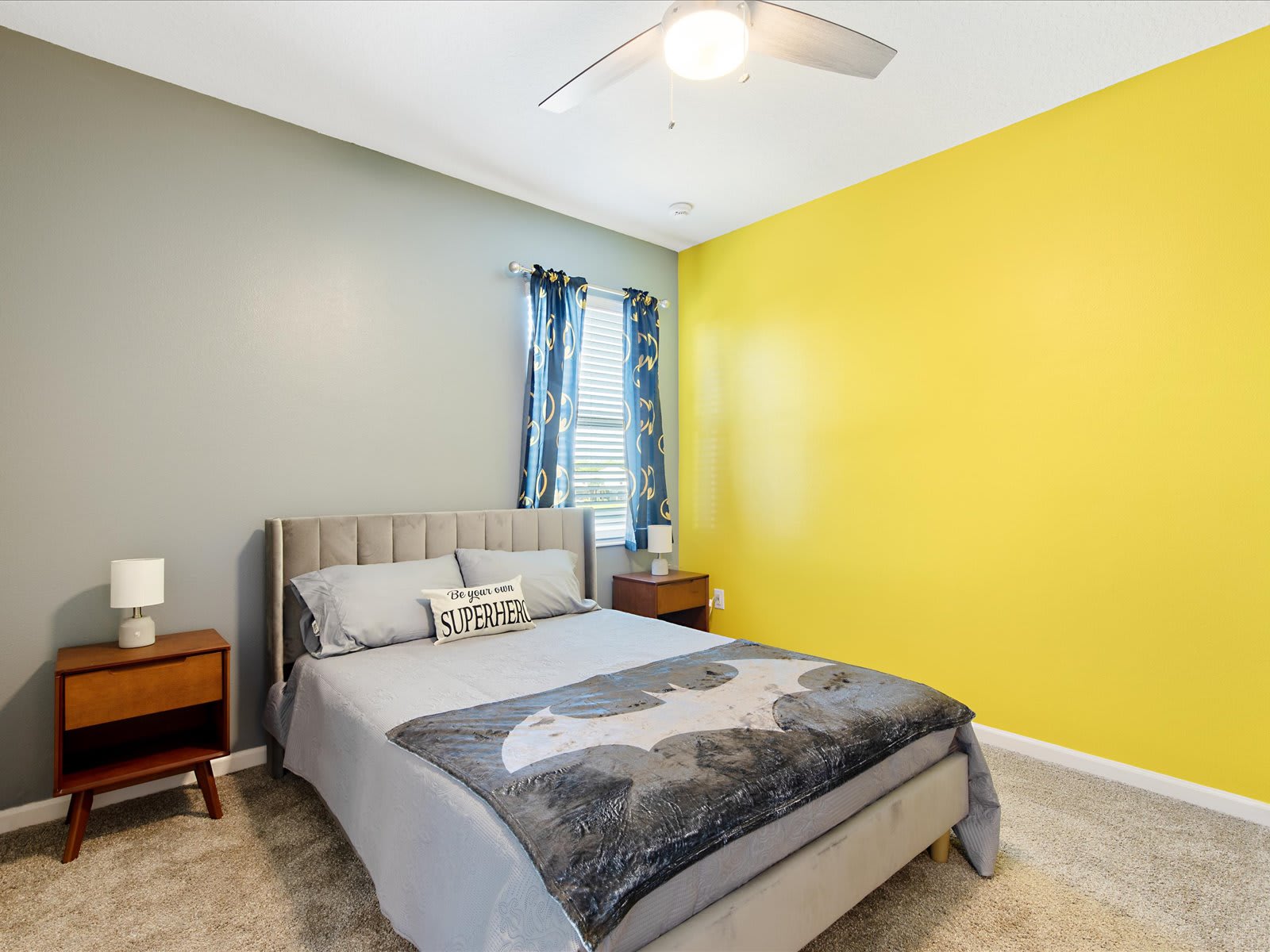 Cheerful bedroom w/ bold accent wall & inviting, cozy layout.
