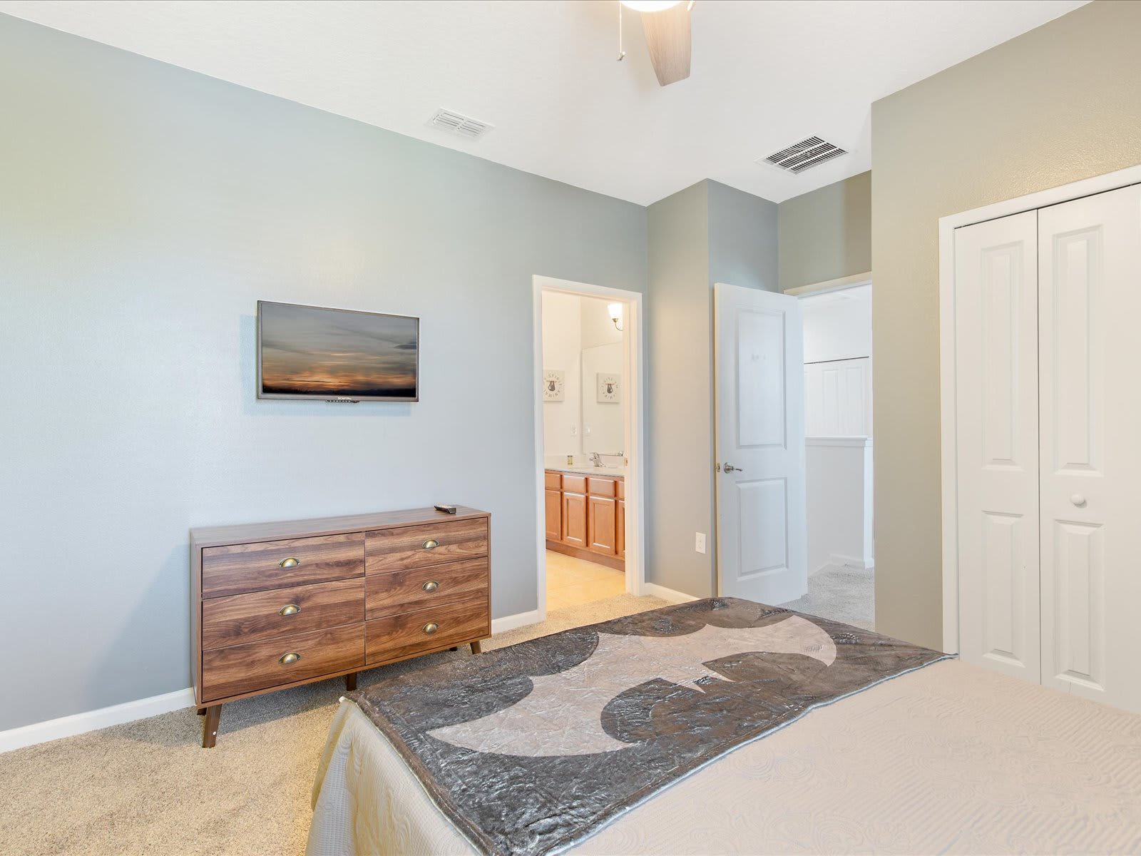 Spacious bedroom w/ dresser, TV, & easy access to the bathroom.