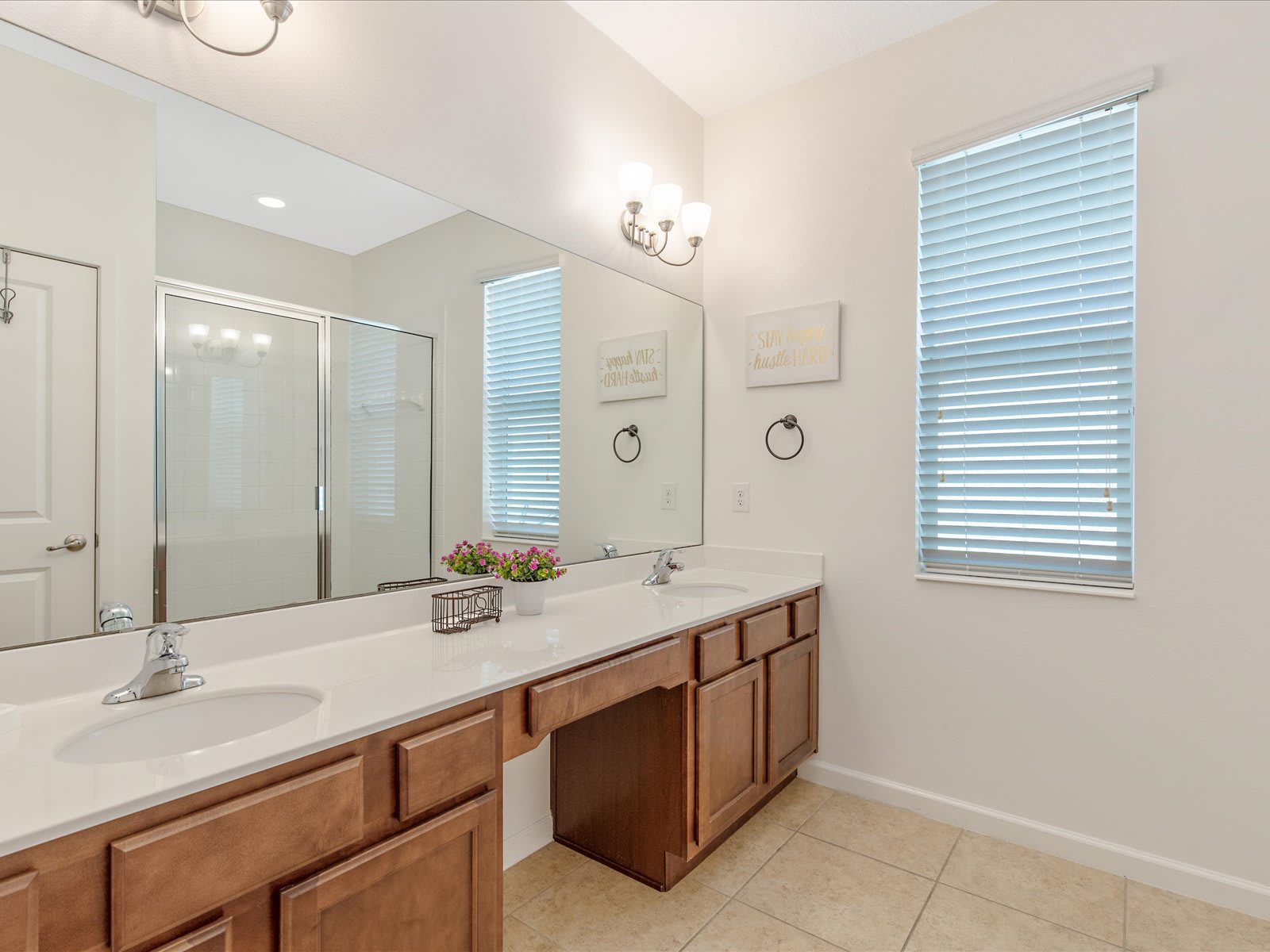 Bright bathroom w/ double sink vanity, mirror, & clean modern finishes.