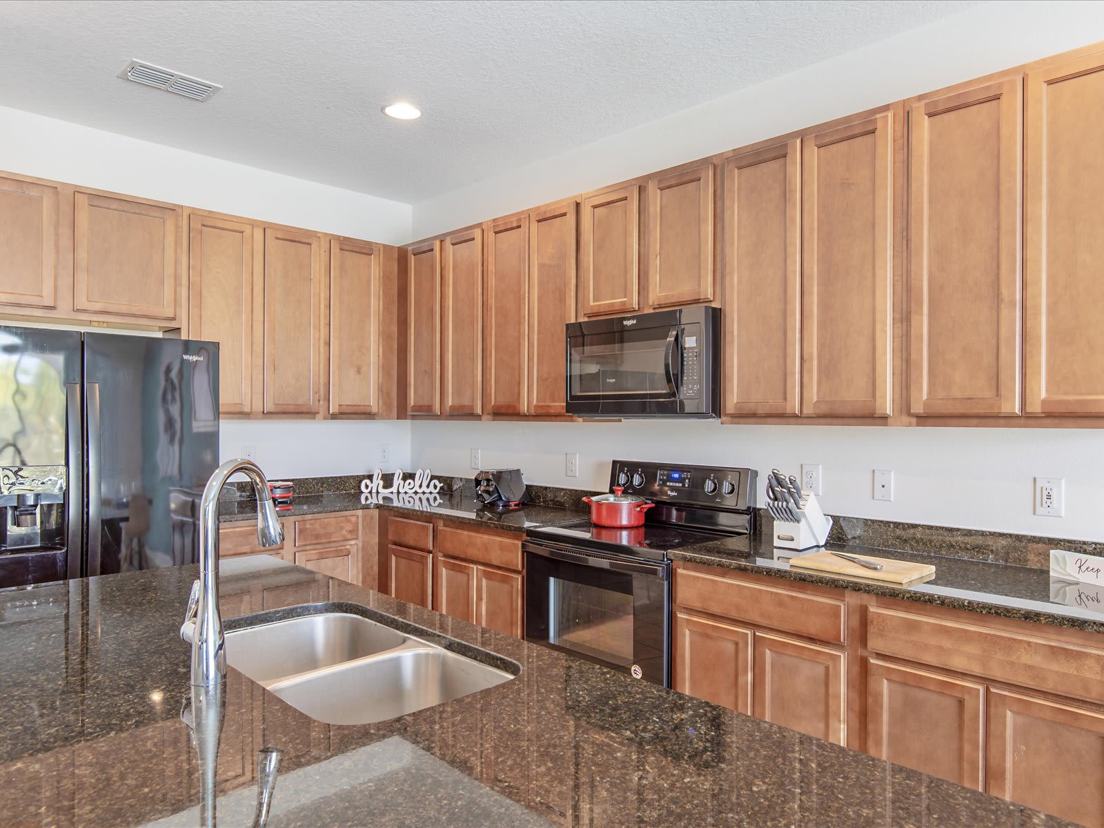 Modern kitchen w/ granite counters, stainless appliances, & ample prep space.