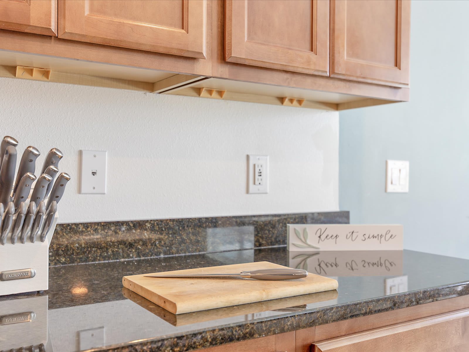Clean kitchen counter setup w/ knife set & cutting board ready for meals.