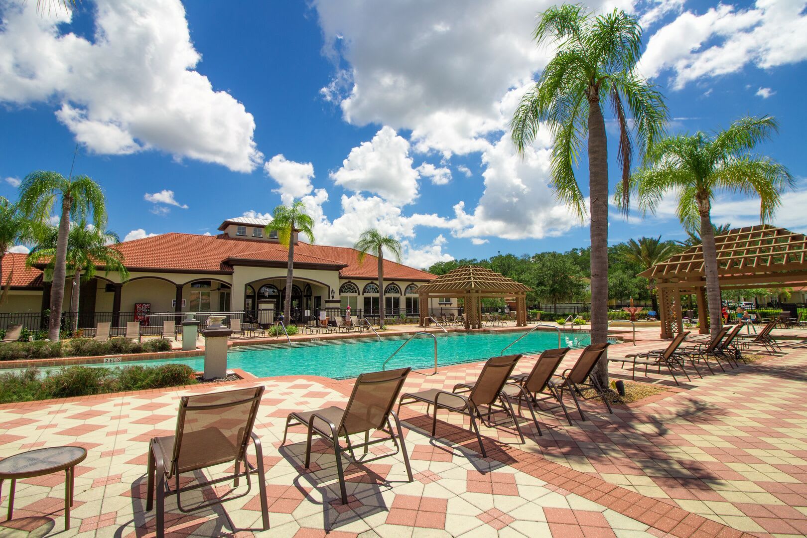 Sunny pool area w/ loungers & palm views, made for relaxed afternoons.