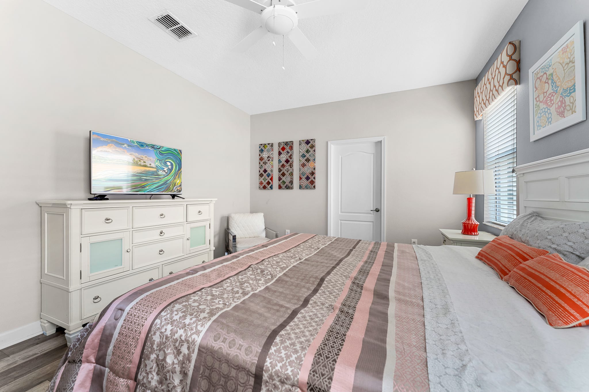 Comfortable bedroom w/ patterned bedding and a clean, uncluttered layout.
