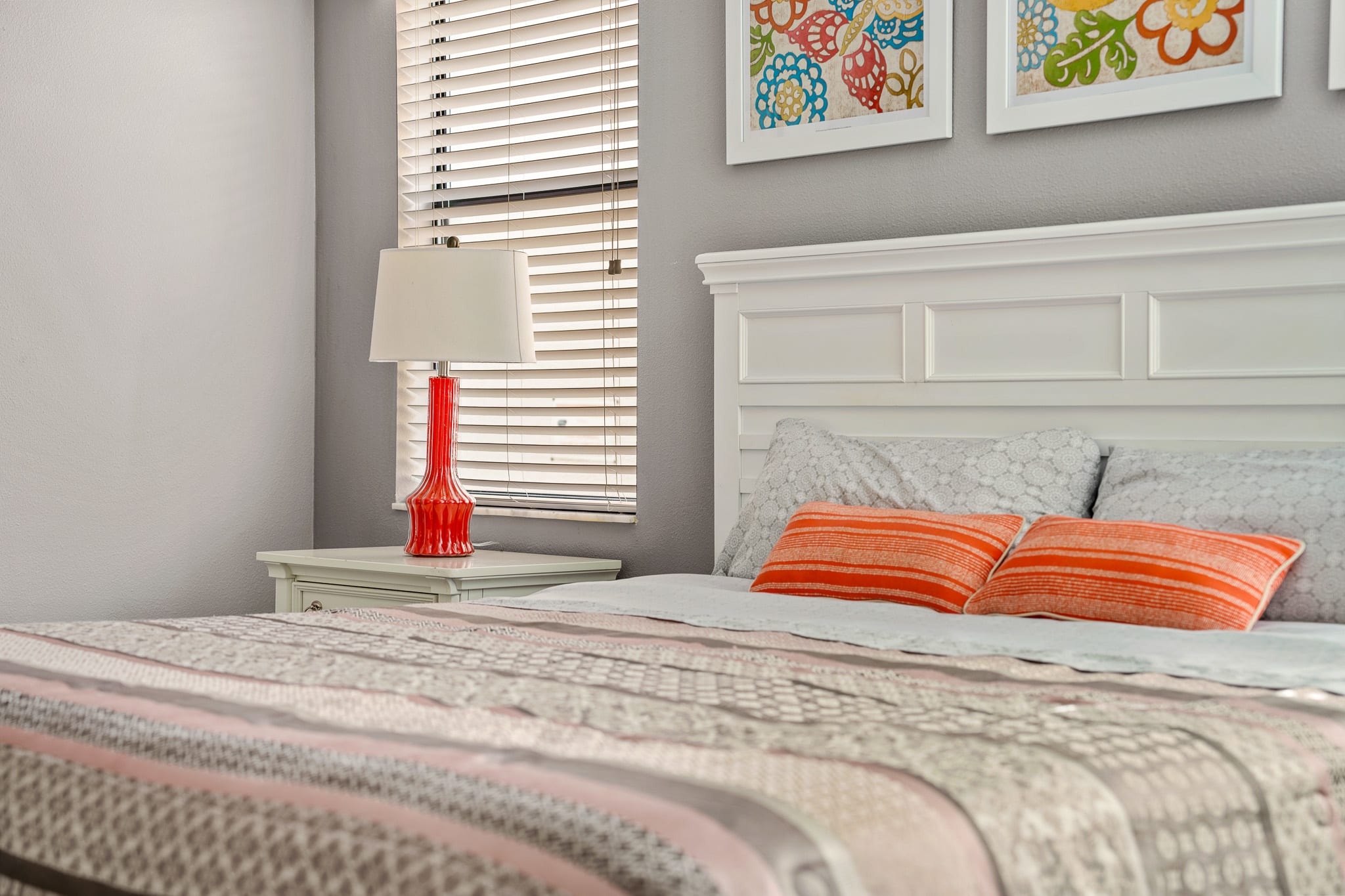 Bright bedroom w/ warm accents and neatly styled bedding.