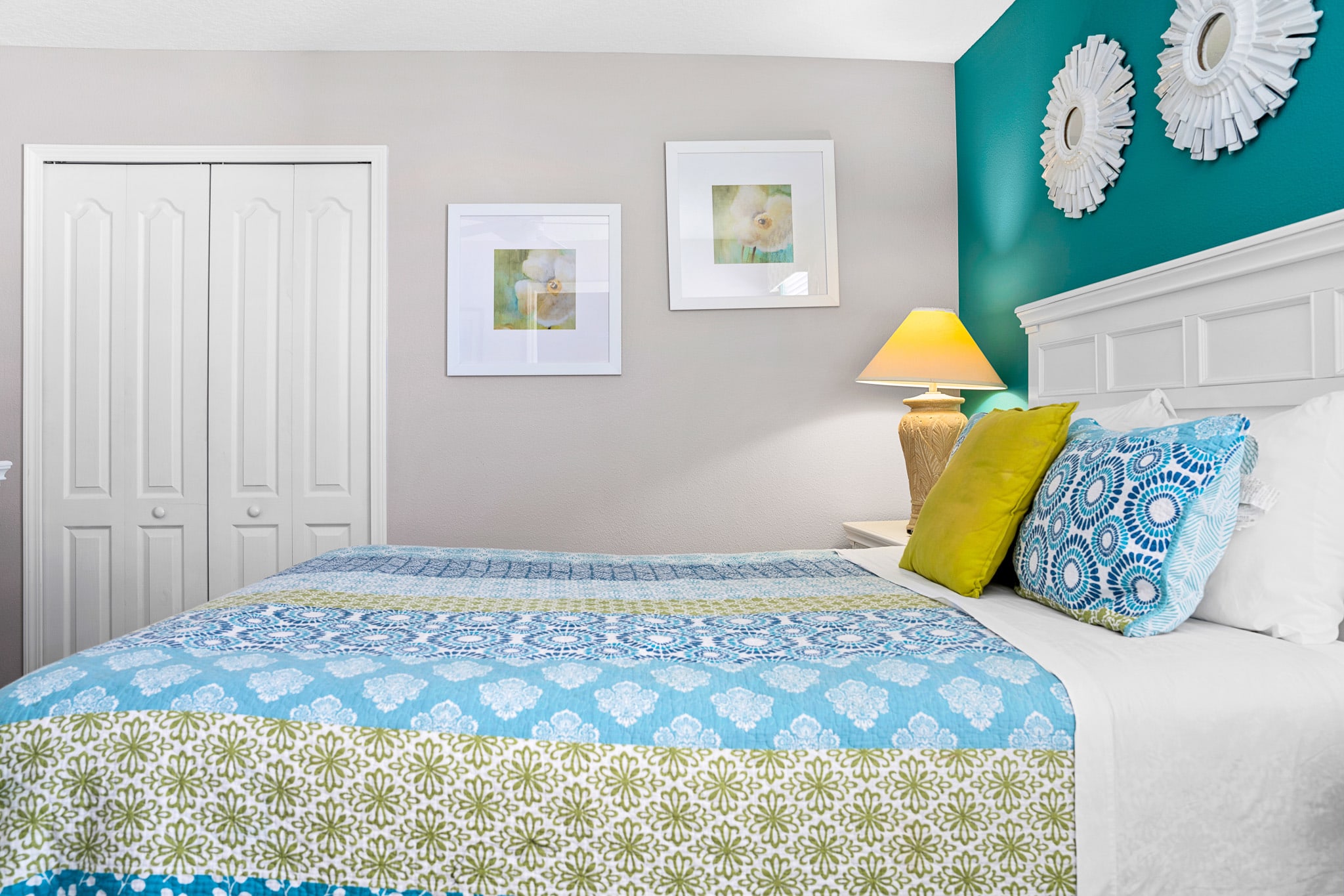 Cozy bedroom w/ patterned bedding and playful accent pillows.