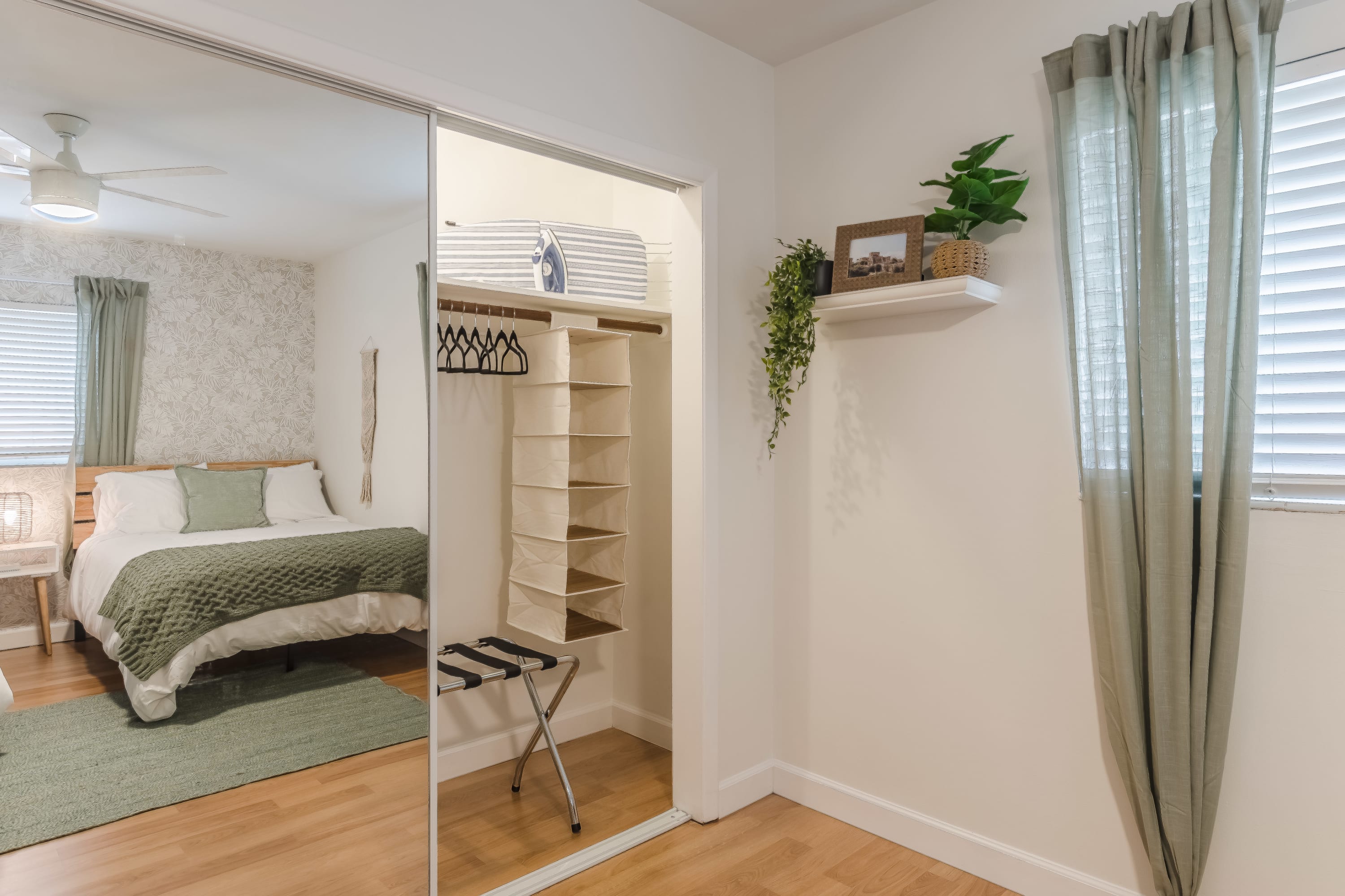 Clean bedroom view w/ simple decor and warm wood floors