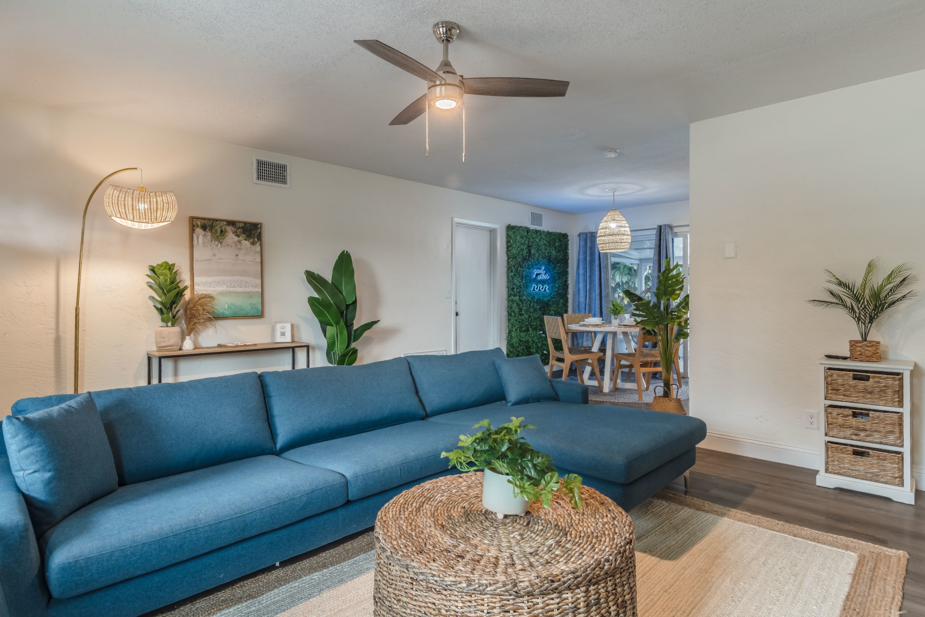 Bright living room w/ comfy seating and ceiling fan for relaxed lounging any time of day.