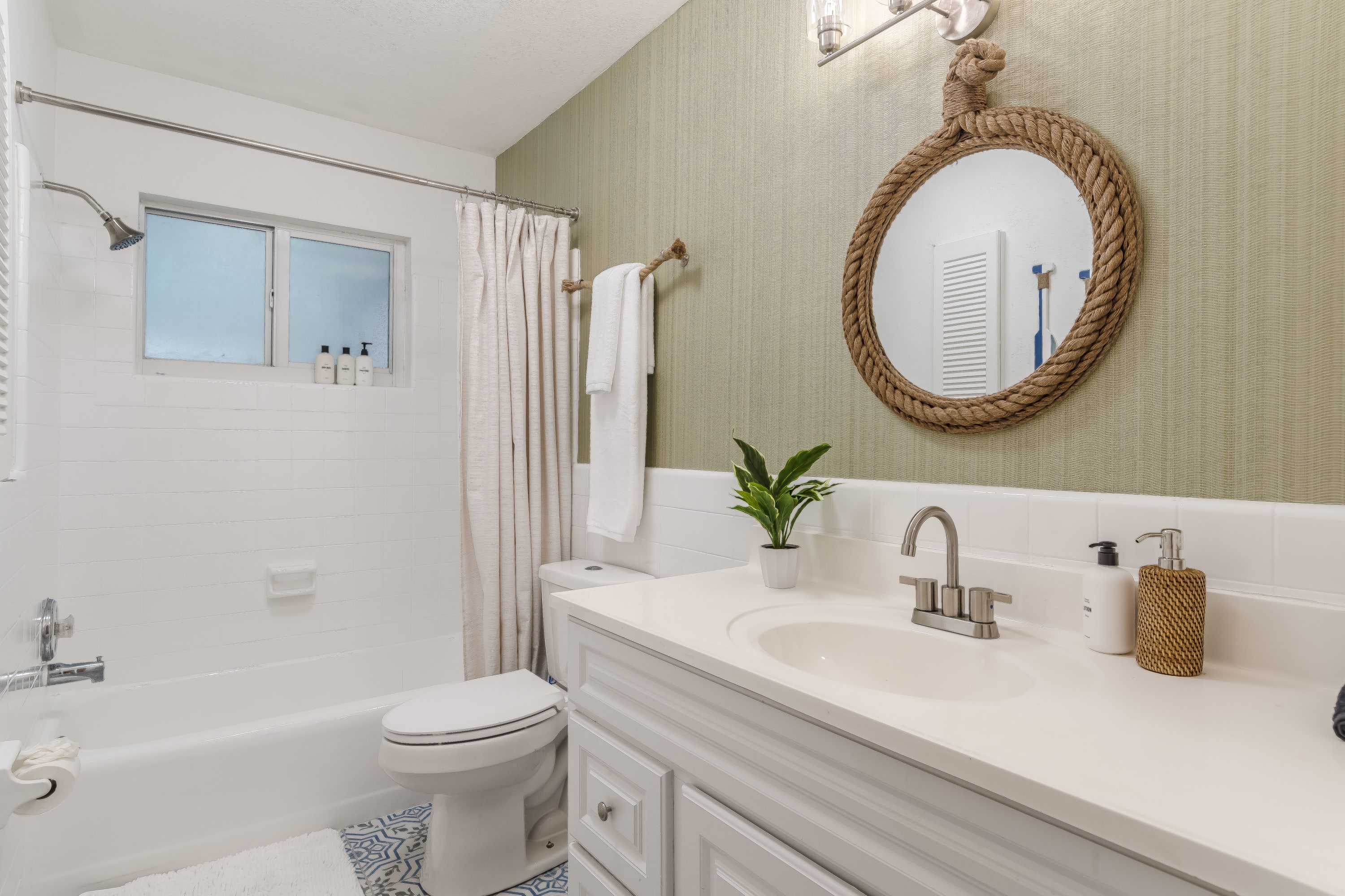 Clean bathroom w/ tub, tiled walls, and soft neutral finishes.