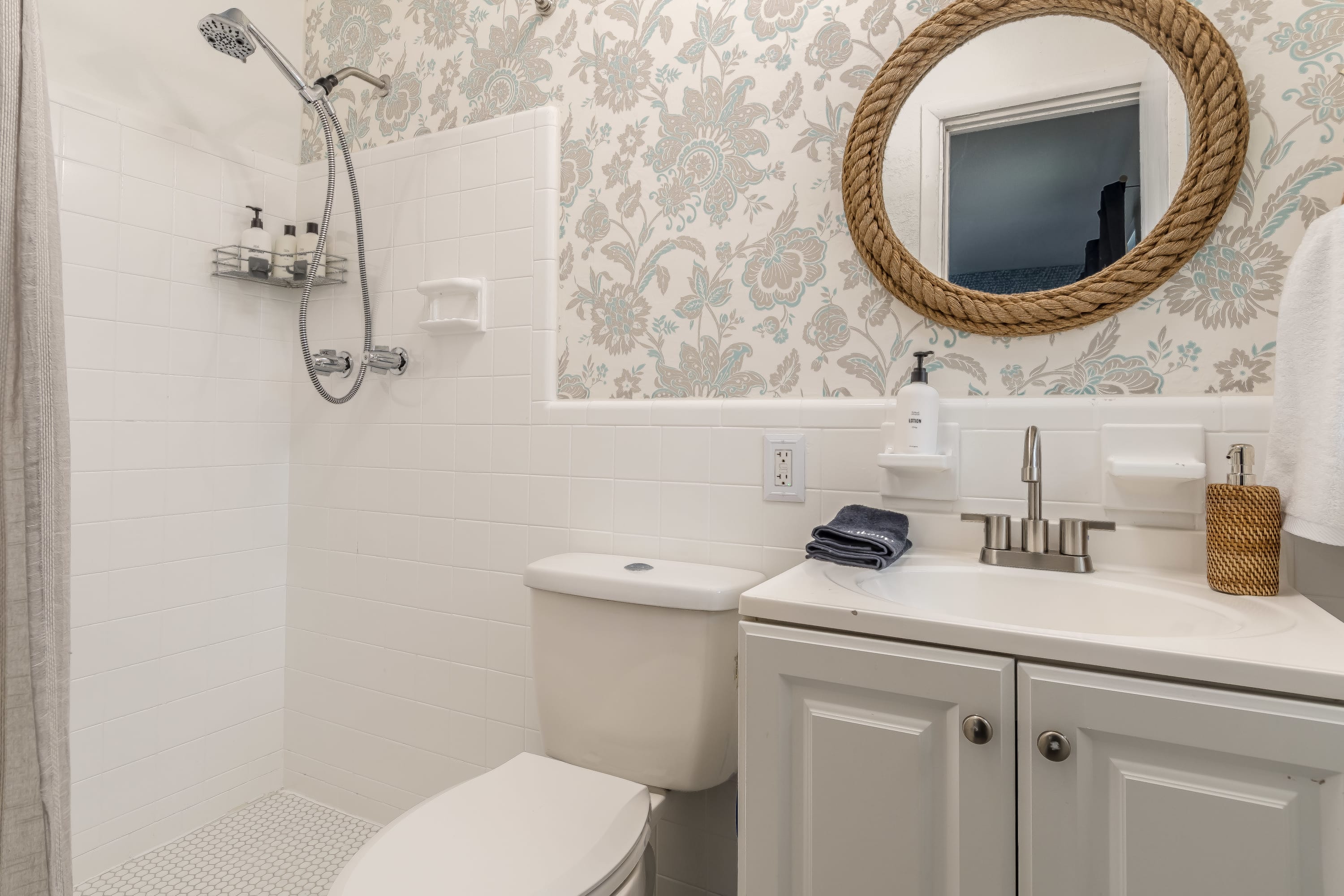 Fresh bathroom w/ vanity, mirror, and neatly styled accents.
