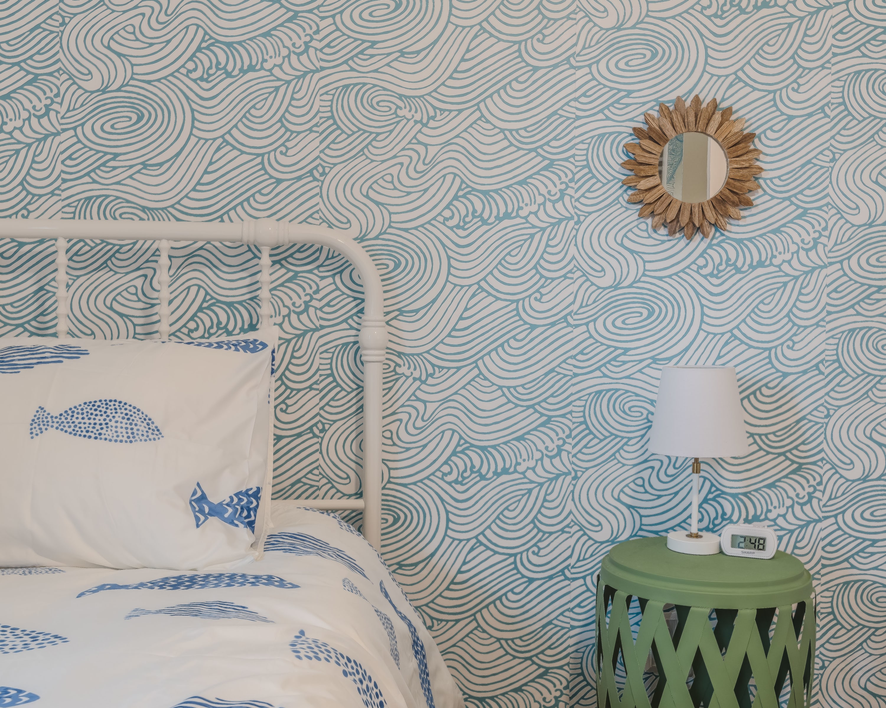 Bedside detail w/ textured wallpaper and gentle lighting that adds a calming feel.