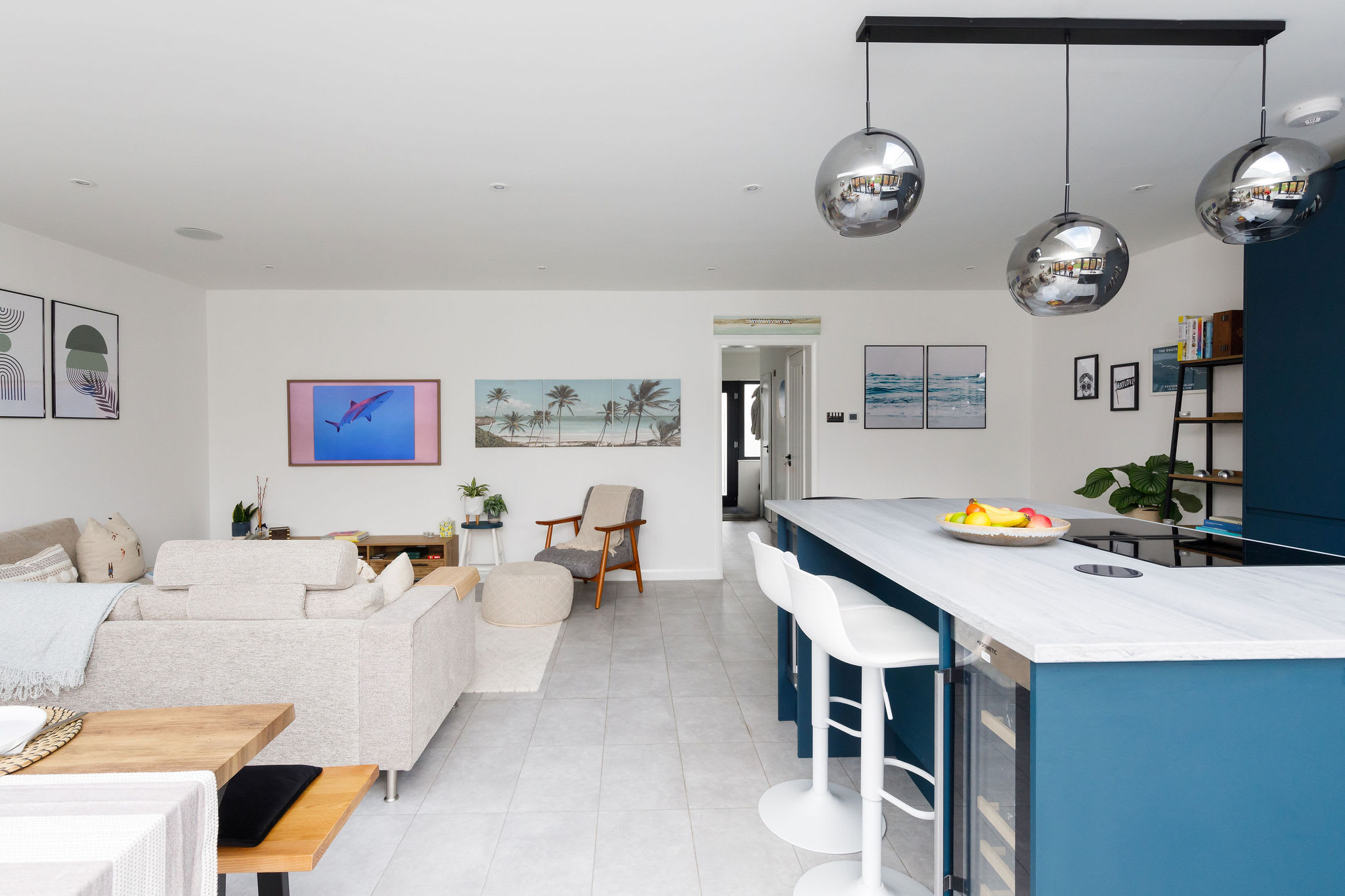 The kitchen island serves as a breakfast bar for 4 with overhead pendant lighting.