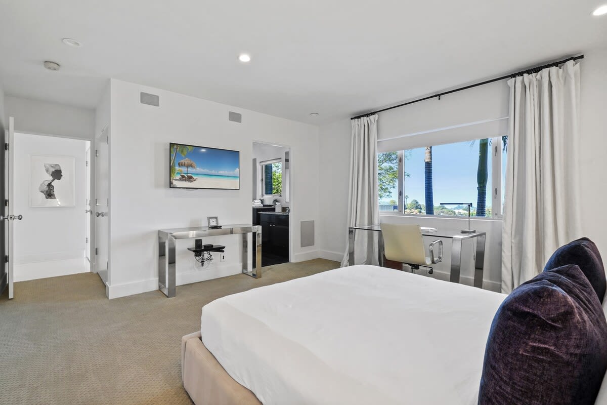 Enjoy the spacious bedroom equipped with a TV and blackout curtains, creating a comfortable and restful sanctuary.