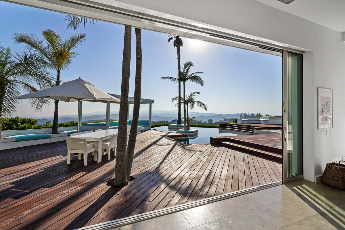 Open the glass doors to embrace the perfect harmony of indoor comfort blending effortlessly with the enchanting outdoor setting.