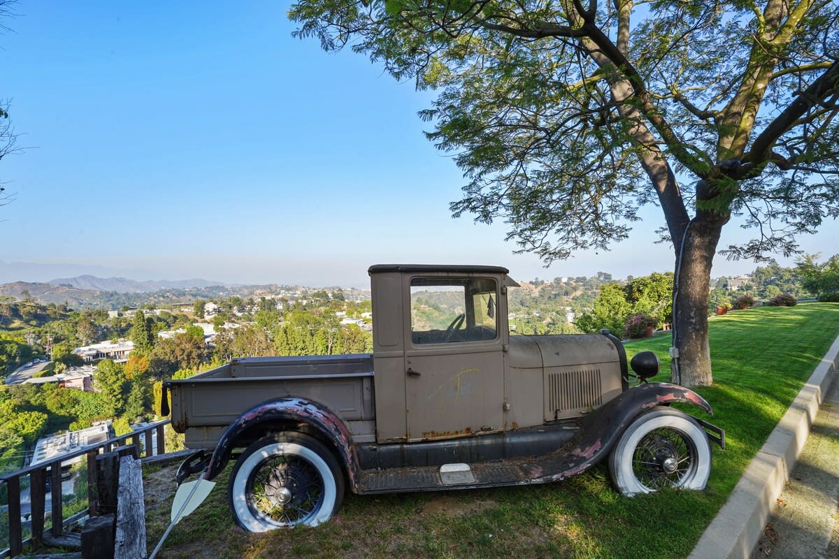 Discover vintage touches in the garden, providing a charming space under a big tree for shade and a lush green lawn.