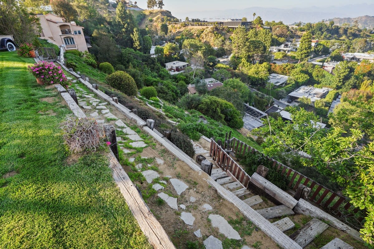 Delight in the beautiful garden with steps cascading down the hill, creating a picturesque outdoor escape.