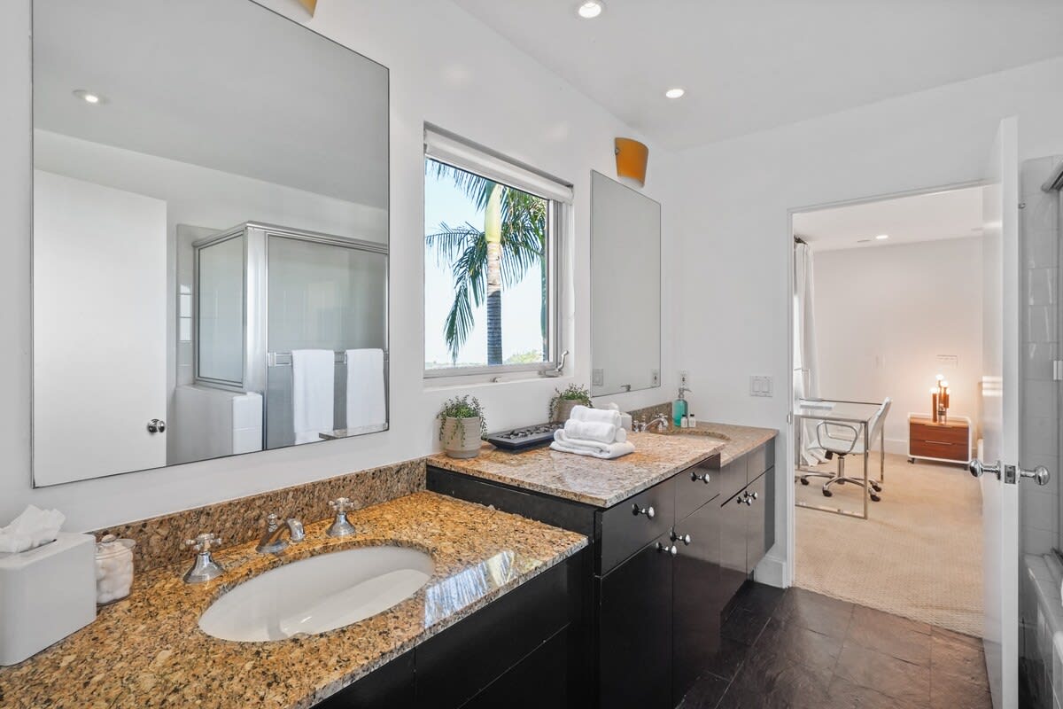 Experience luxury in the ensuite bathroom with elegant marble countertops, featuring his and hers sinks for added convenience.