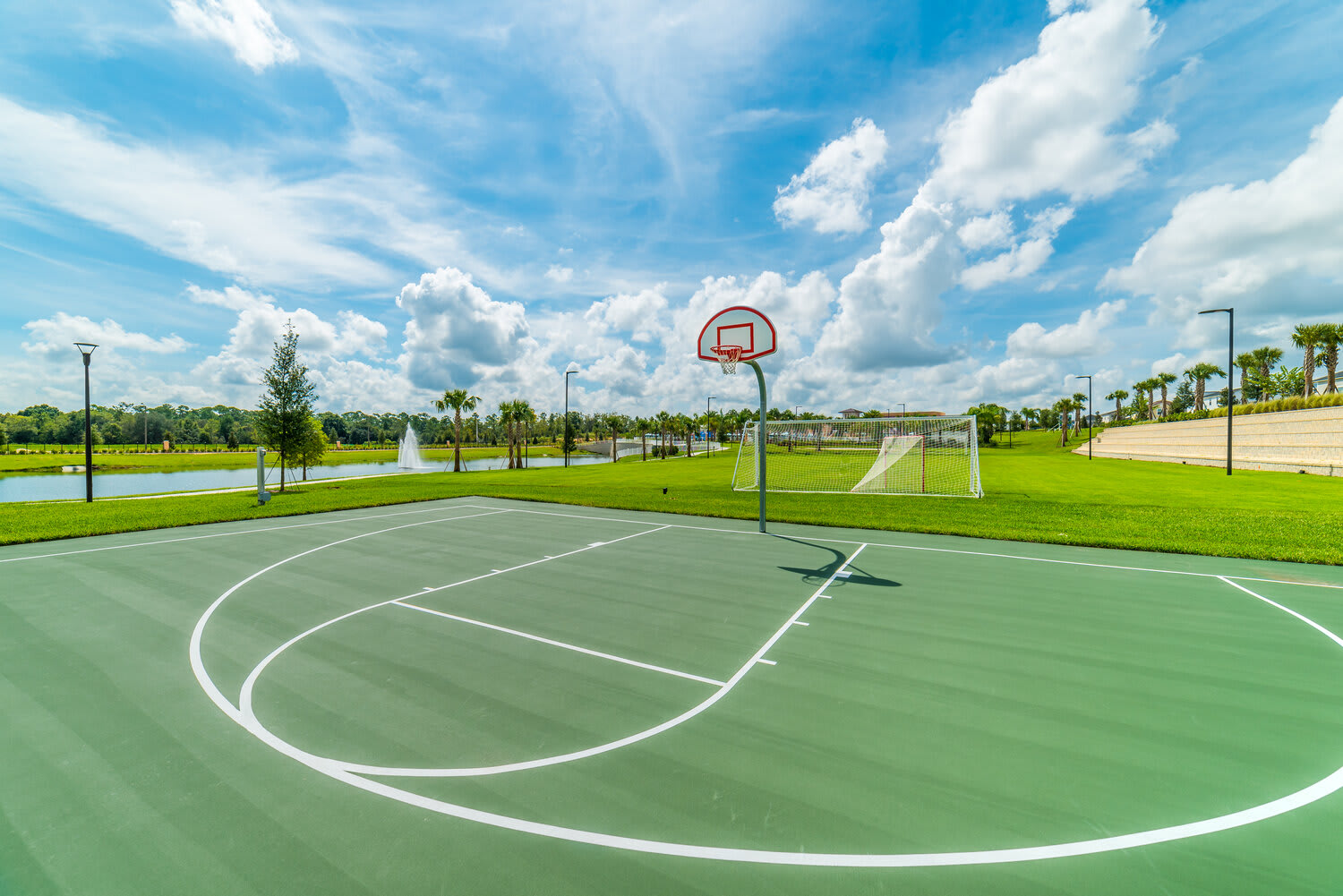 Outdoor basketball court with scenic lake and green space views