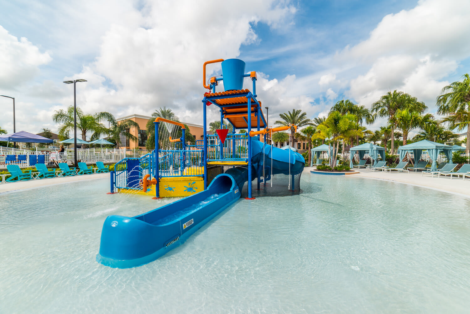 Family-friendly water play area with slides and splash features in a tropical pool setting