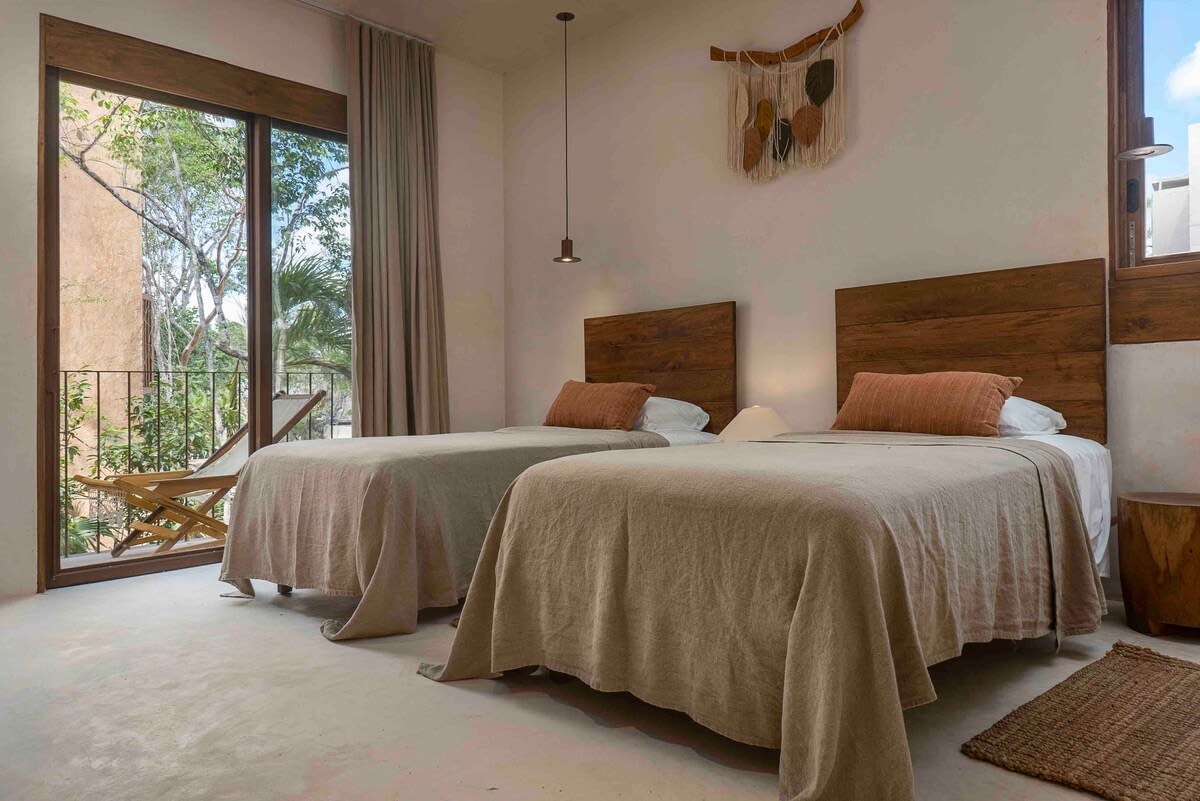 Bedroom 3, on the second floor, equipped with two single beds, ensuite bathroom, and patio access