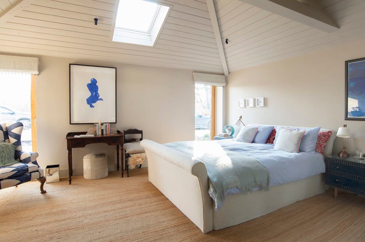 A wonderful bedroom with king bed, armchair and impressive artwork.