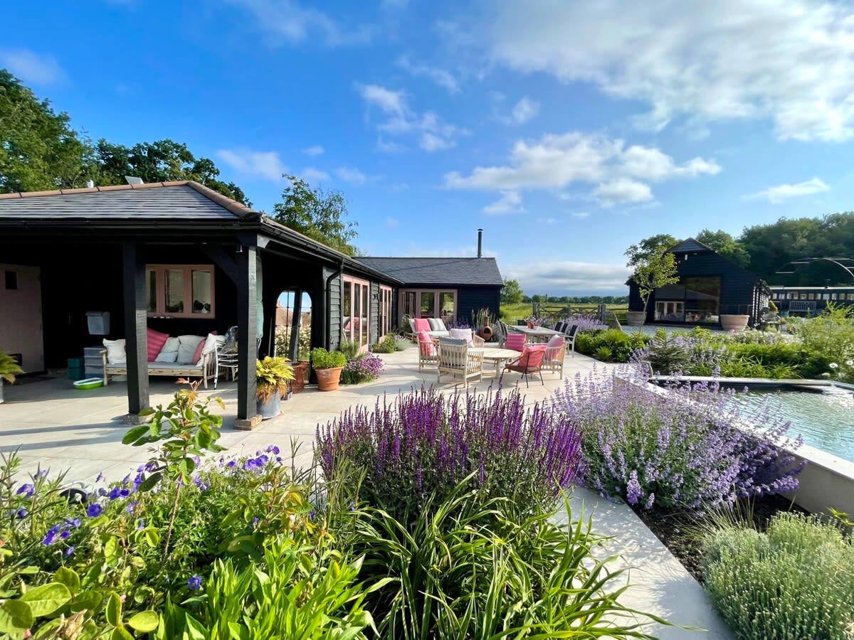 The garden is well manicured and maintained, with pretty borders and raised pond.