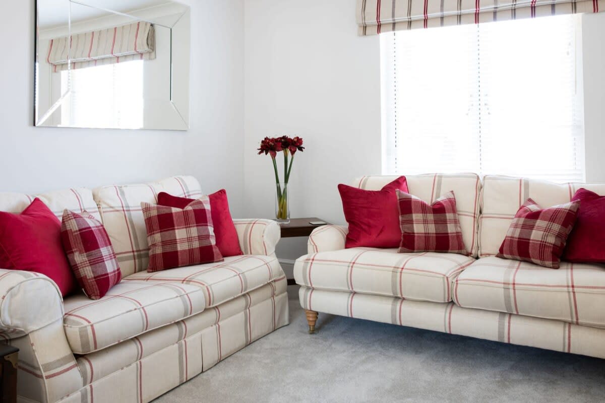 The living room has plenty of seating, with two sofas and two armchairs.