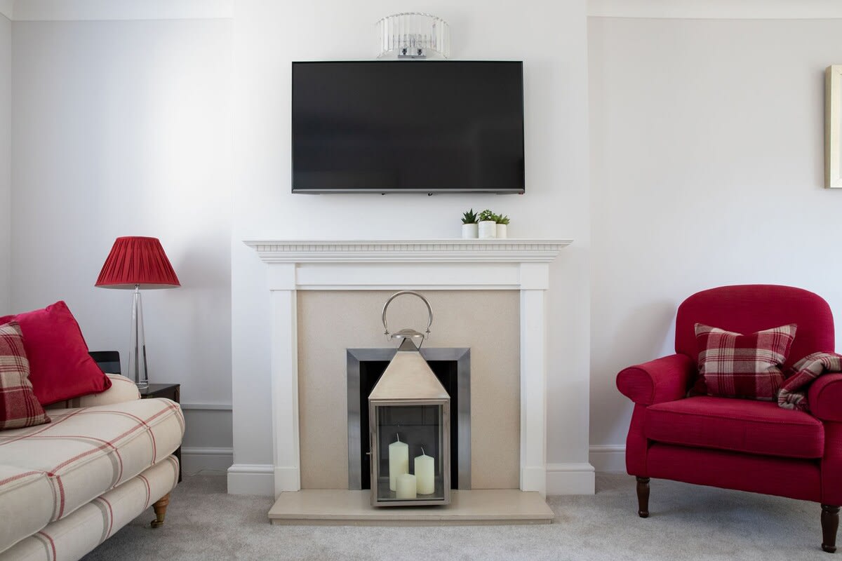 Your own flat screen TV is wall-mounted above the feature fireplace.
