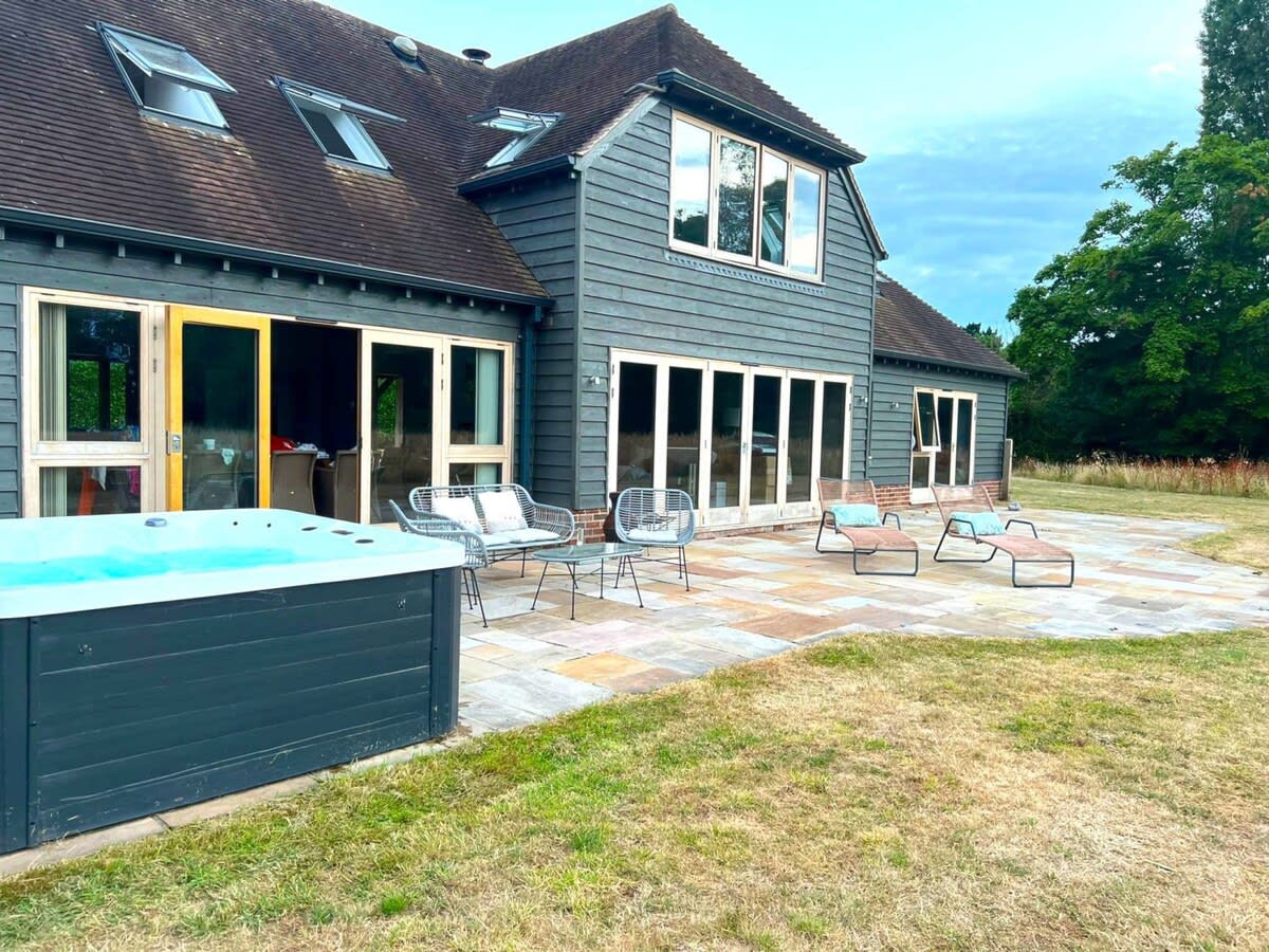 The home has a beautiful rear patio with outside furniture, sun loungers and hot tub.