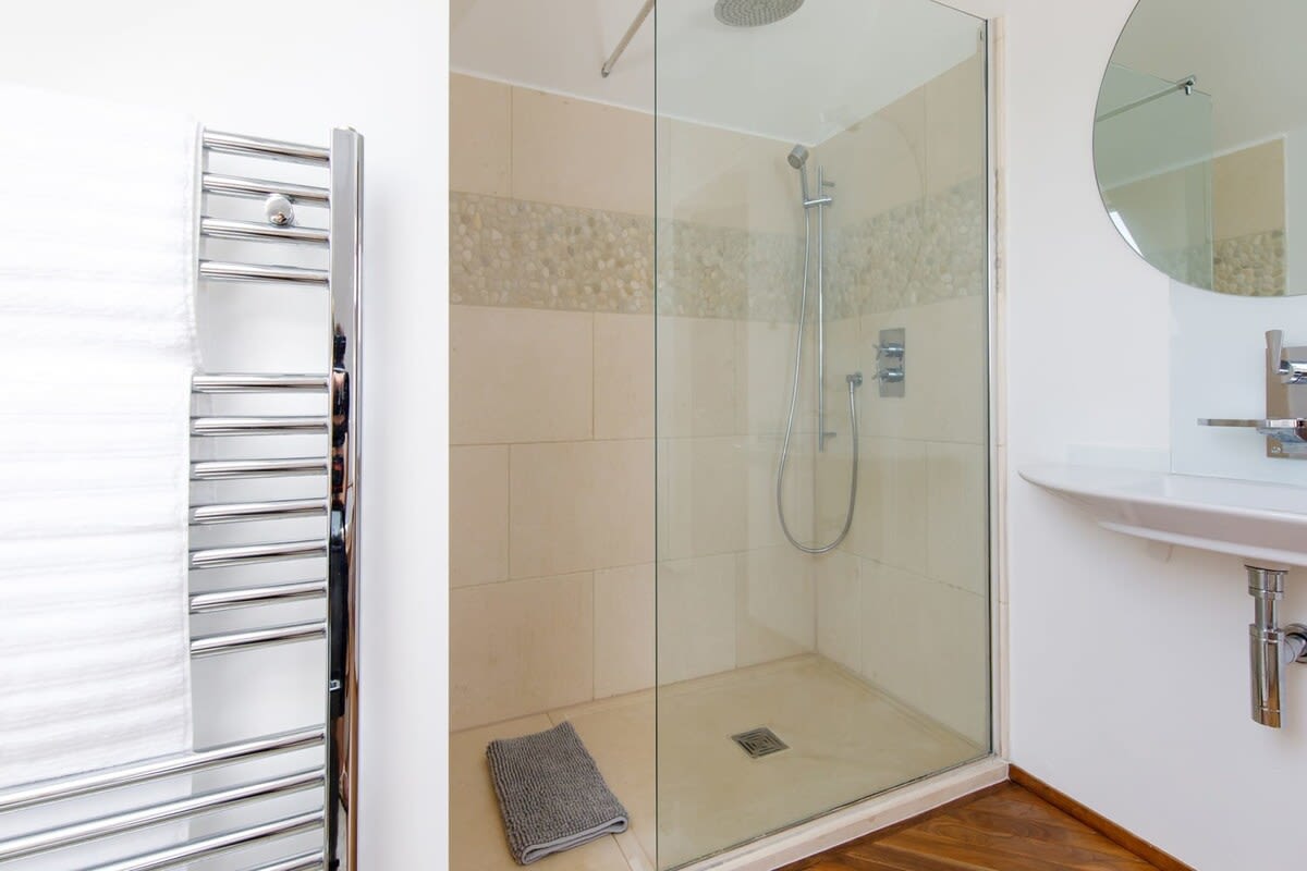 The walk-in shower has a large rainfall shower head.