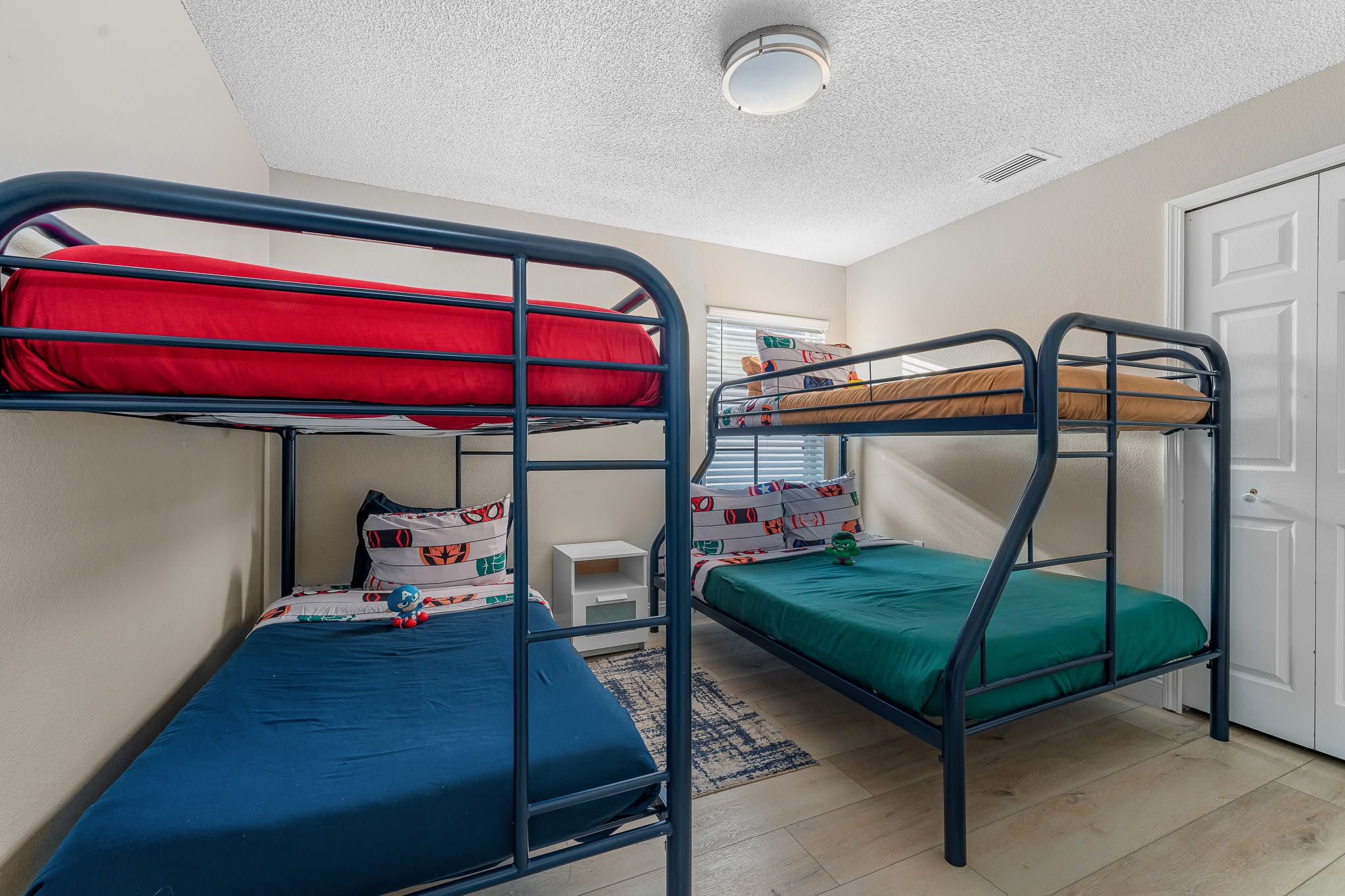 Spacious bunk room w/ multiple beds and a lively, playful atmosphere.