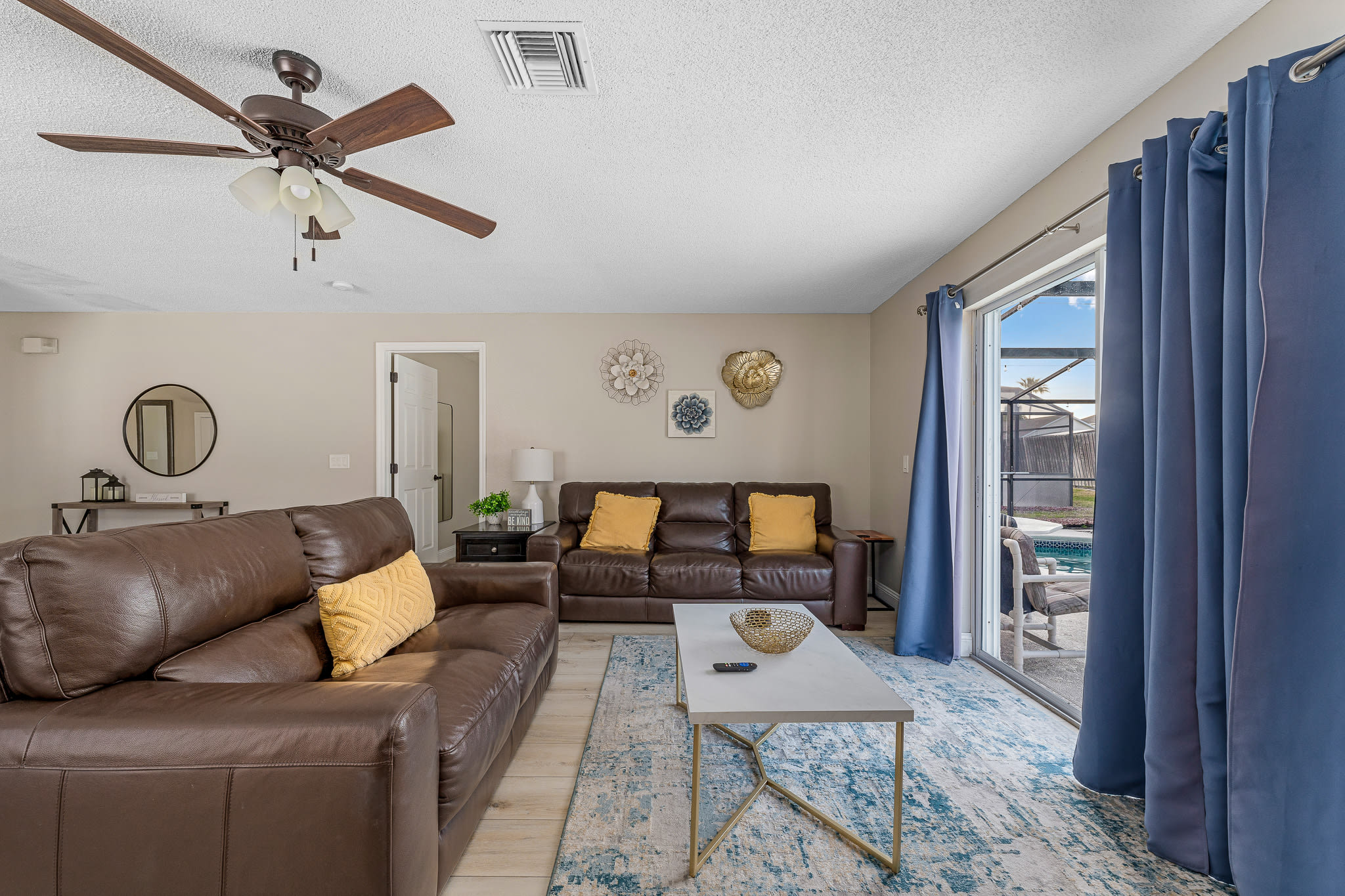 Bright living room w/ comfy seating, coastal accents, and natural light throughout.