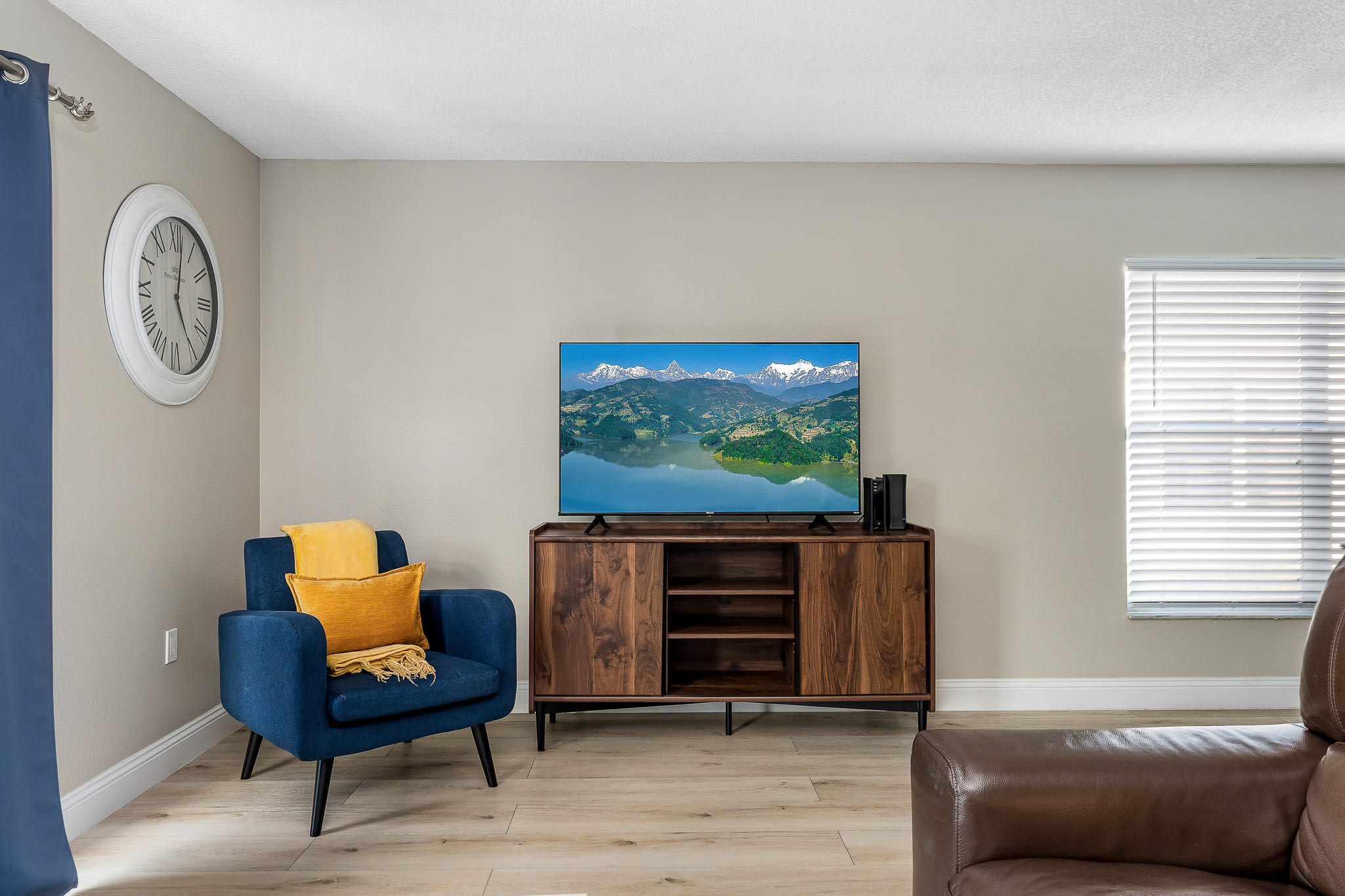 Cozy media corner w/ TV, accent chairs, and warm lighting.