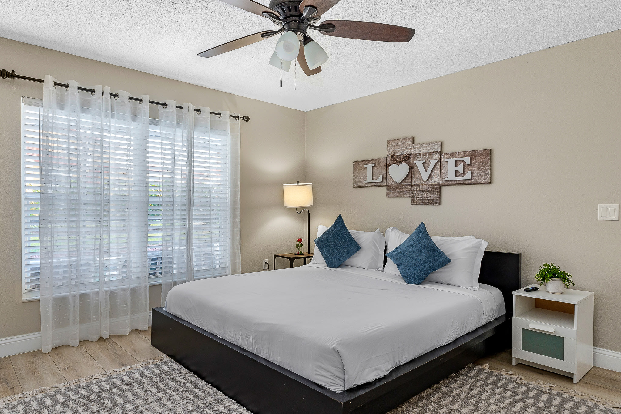 Peaceful bedroom w/ soft linens, neutral tones, and gentle natural light.