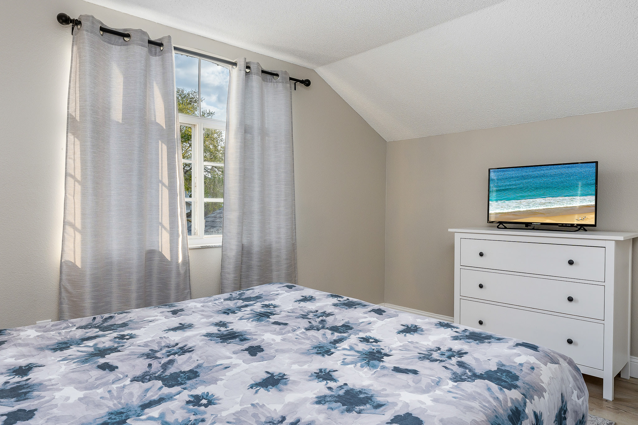 Relaxing bedroom w/ soft colors, ceiling fan, and a tidy, open feel.
