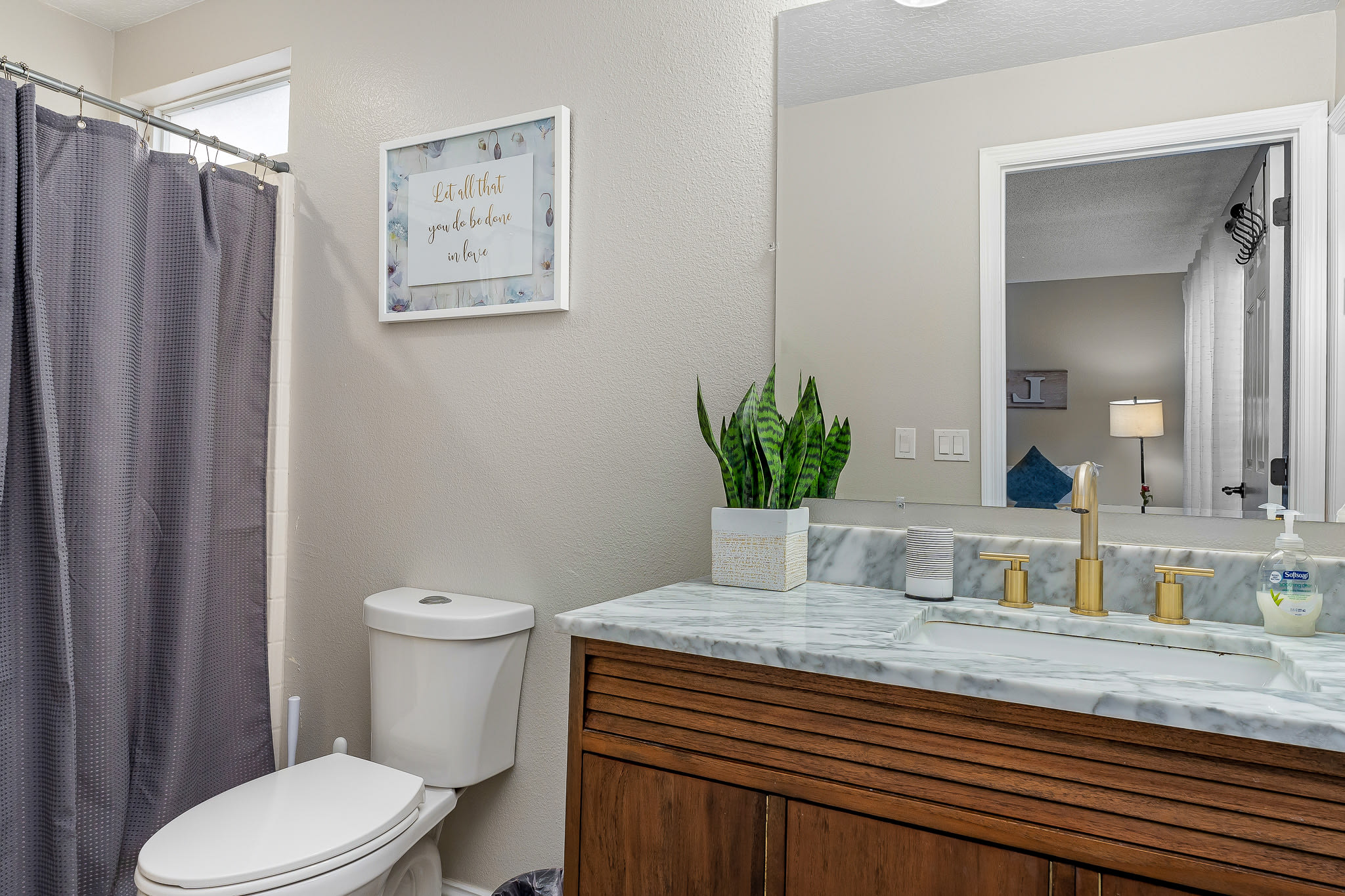 Clean bathroom w/ tub & shower combo, curtain enclosure, and simple finishes.