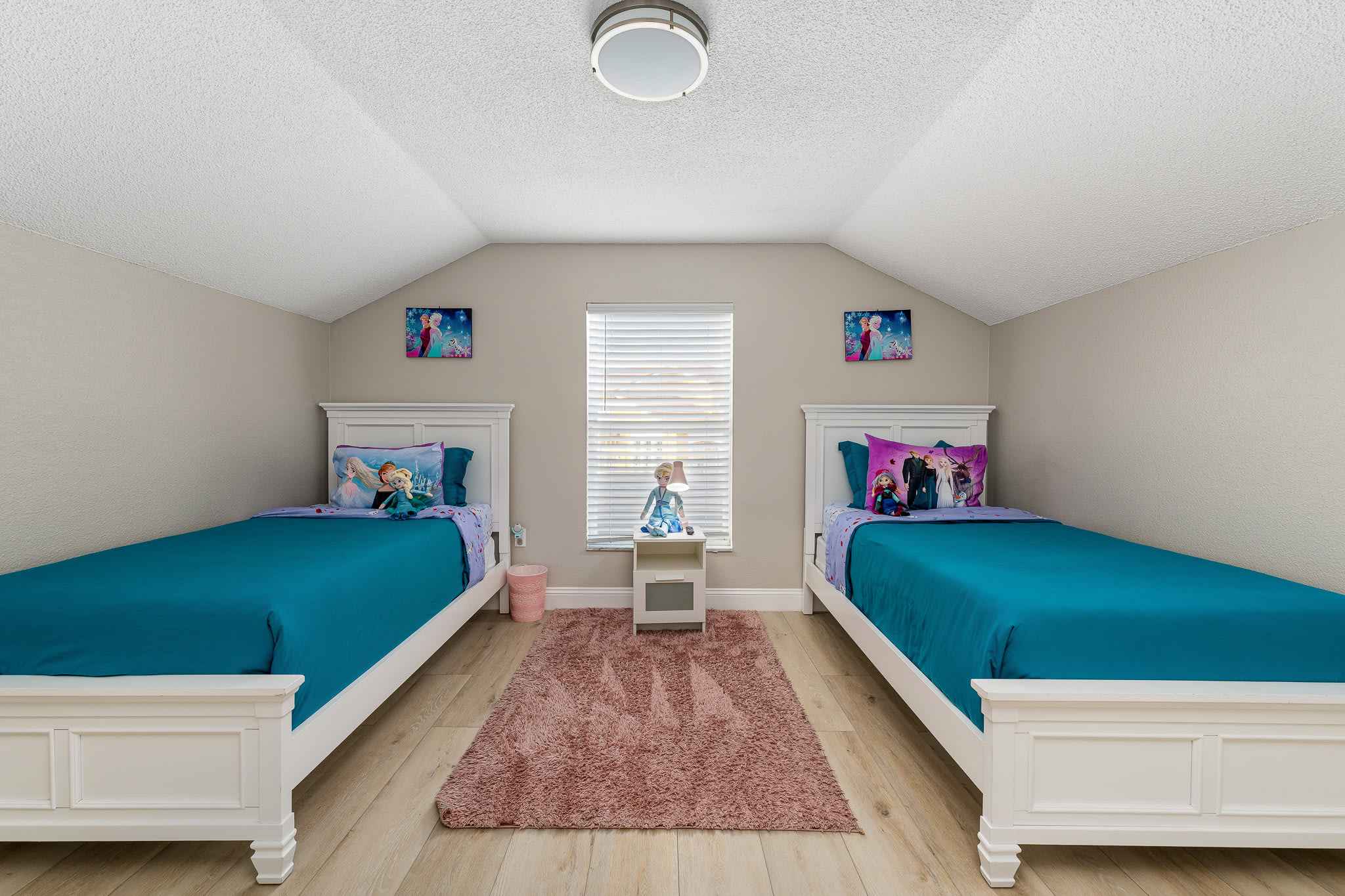 Colorful bedroom w/ twin beds, playful decor, and a fun, family-friendly feel.