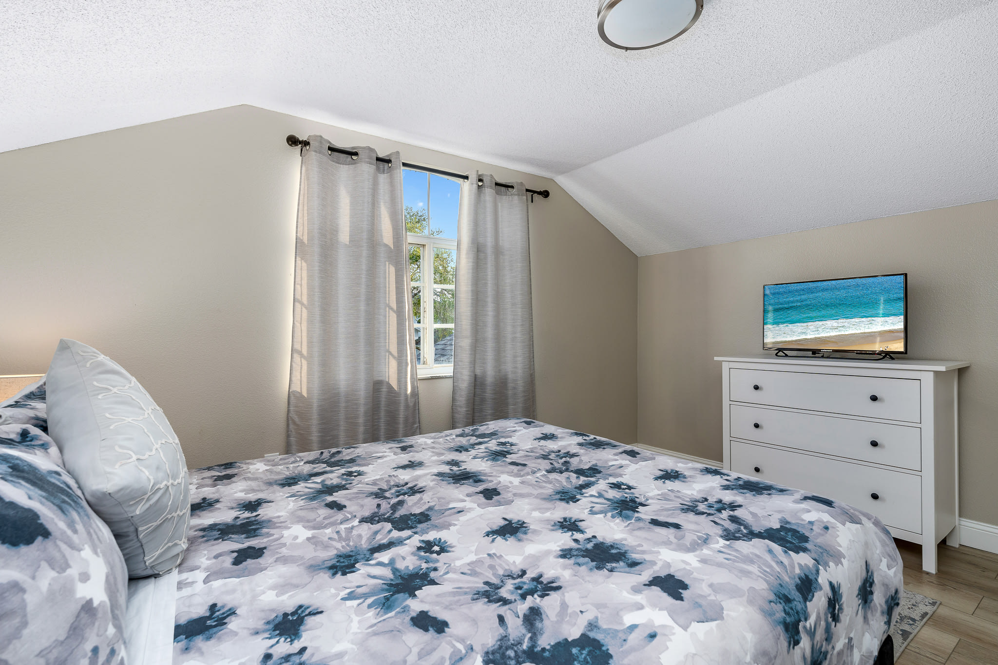 Bright sleeping space w/ coordinated bedding and cheerful wall art.